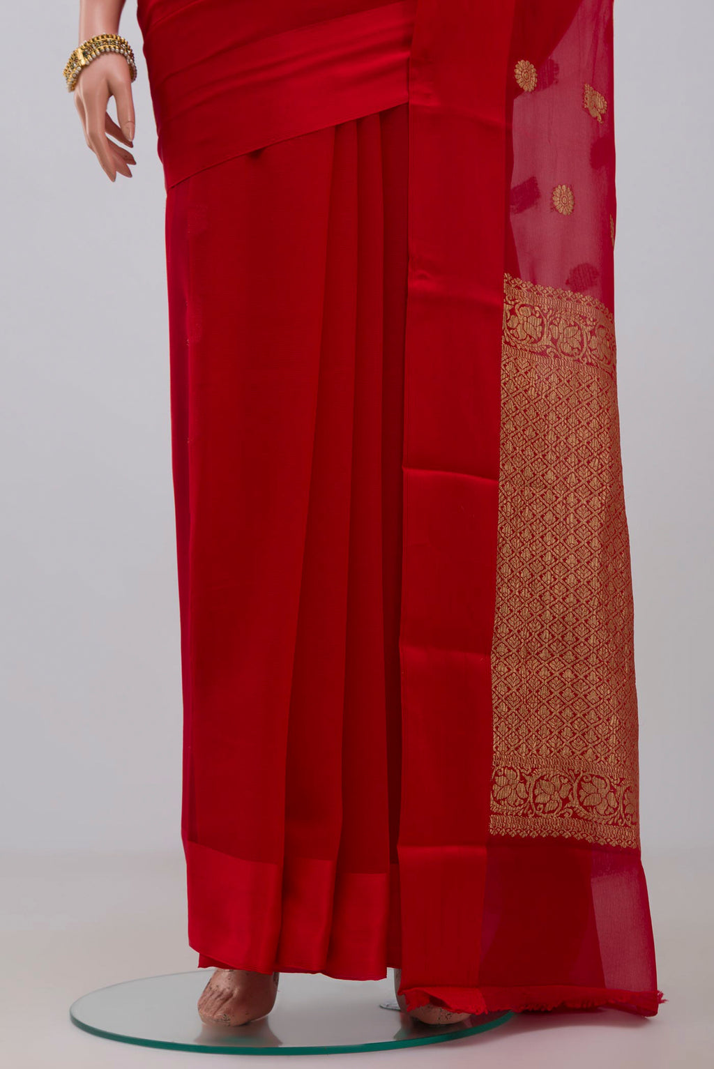 Pleats and pallu of Red Chiffon Saree with Zari Butta on the body and Plain Border. 