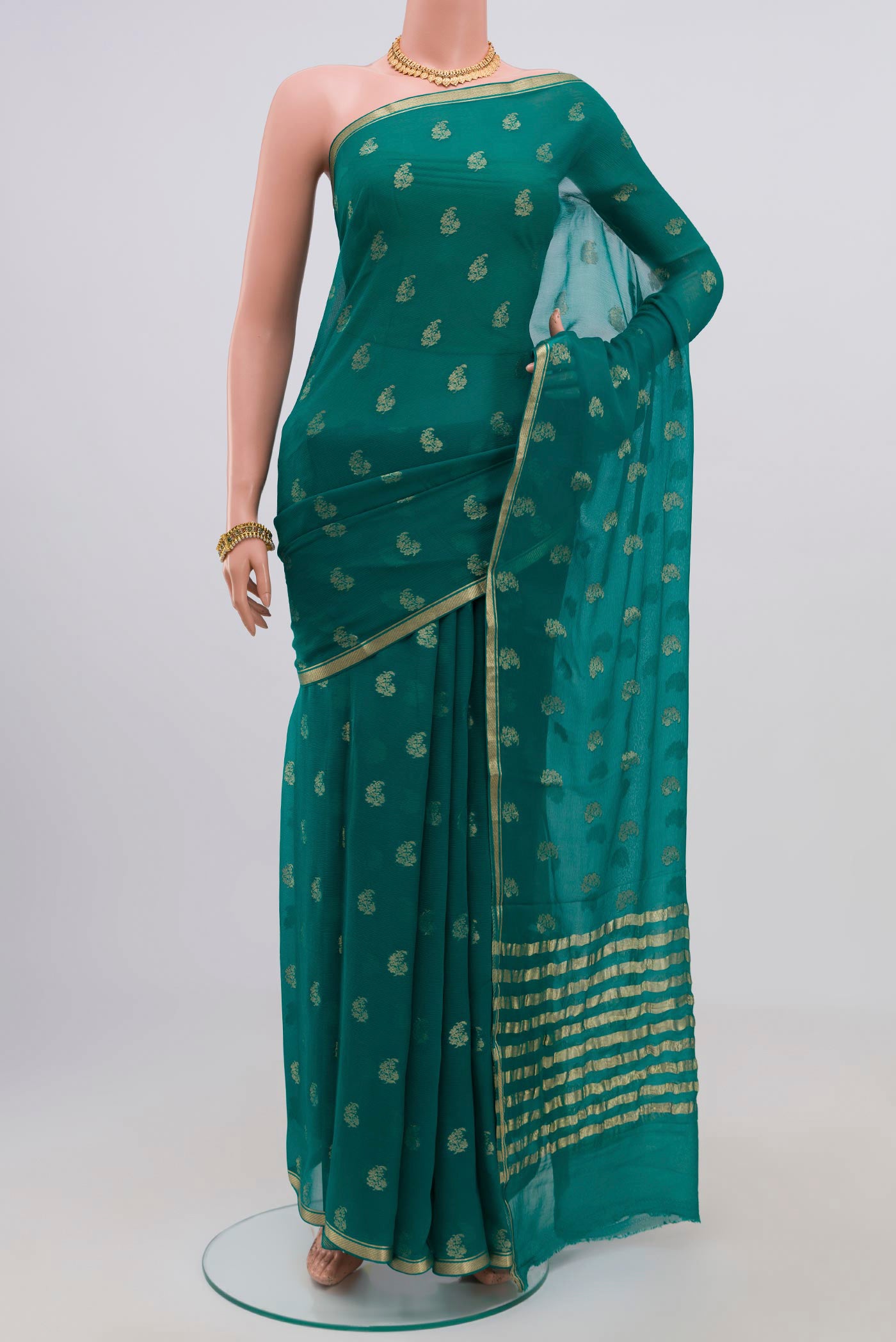Green Chiffon Saree with Zari Butta on the body and Zari Border.  displayed on a mannequin