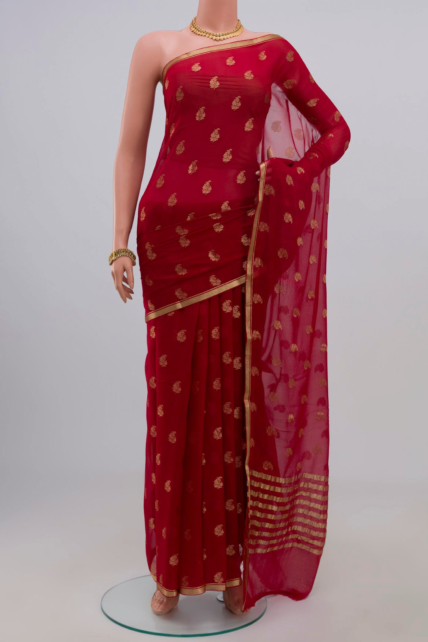 Red Chiffon Saree with Zari Butta on the body and Zari Border.  displayed on a mannequin