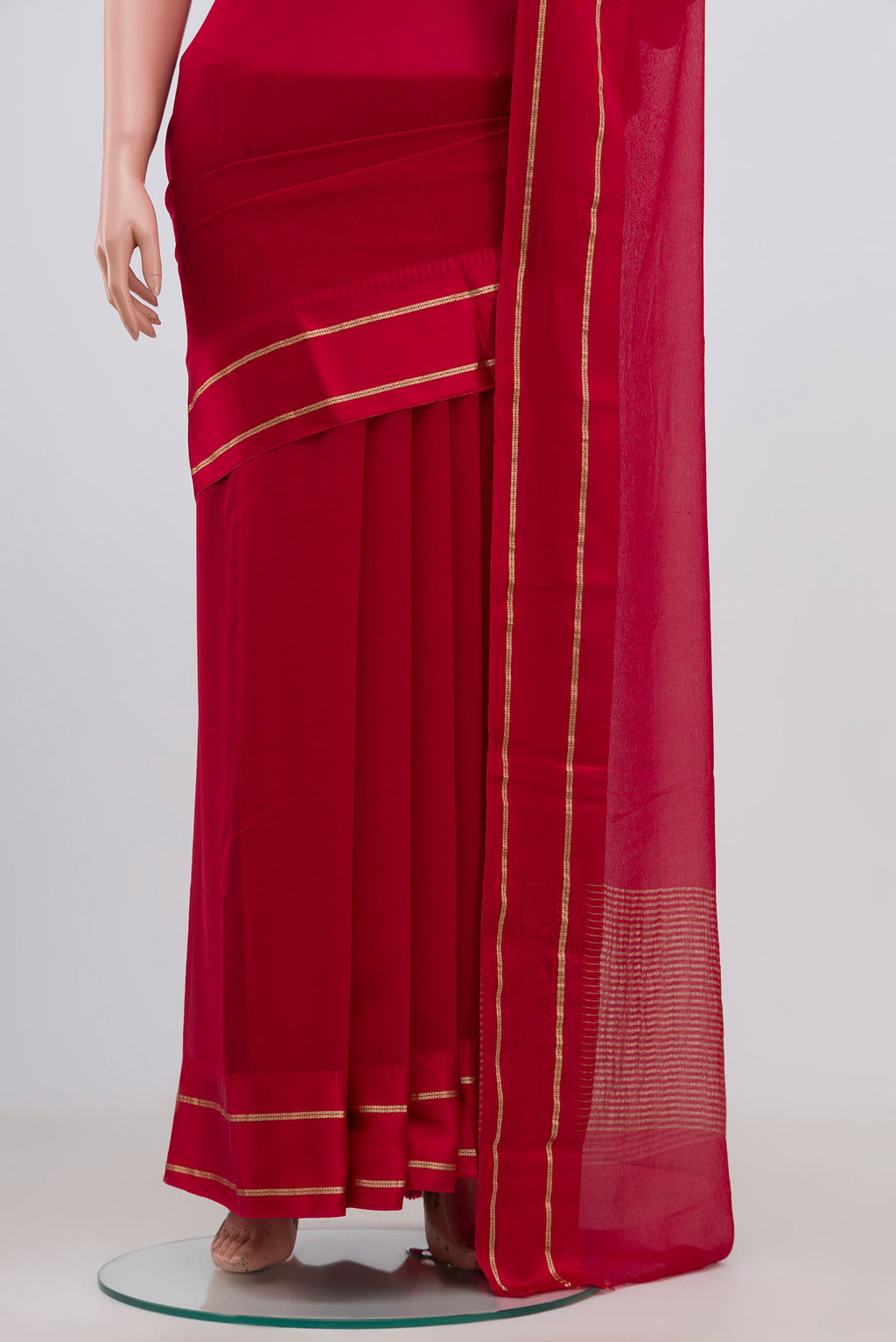 Pleats and pallu of Red Chiffon Saree with Plain Body and Thin Zari Line. 