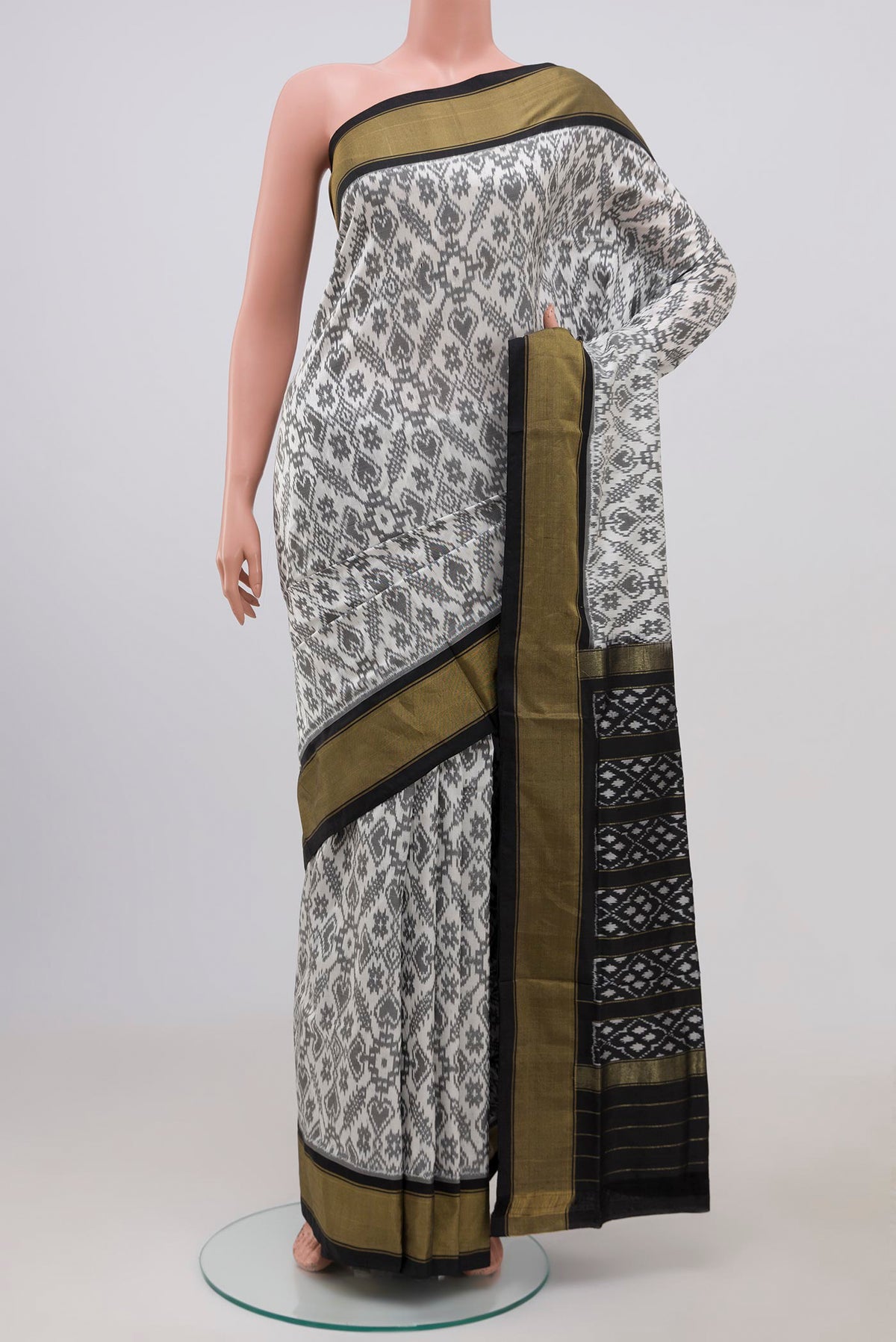White Pochampally Silk Saree with Ikat Print on the body and Zari Border.  displayed on a mannequin