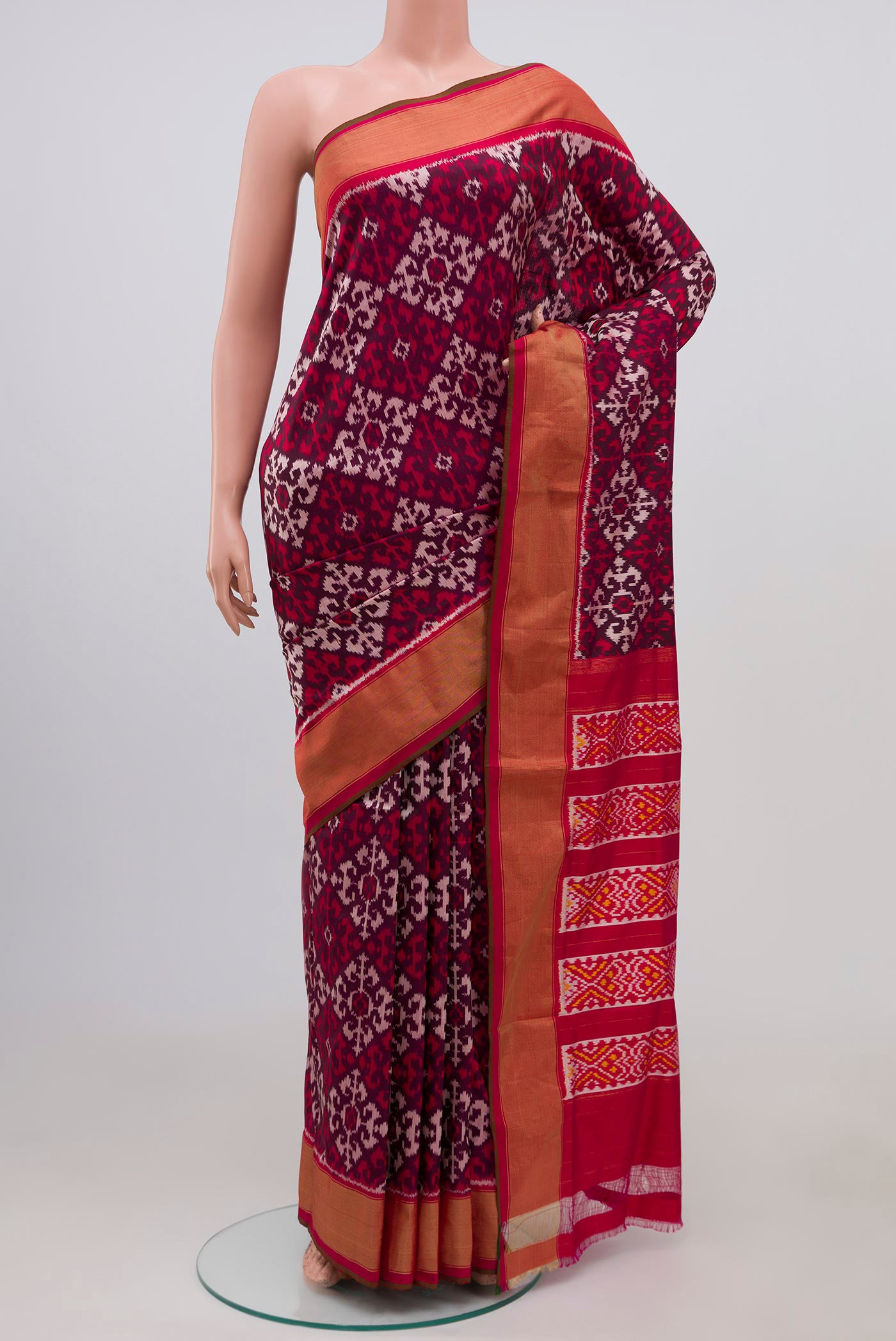Brown Pochampally Silk Saree with Ikat Print on the body and Zari Border.  displayed on a mannequin