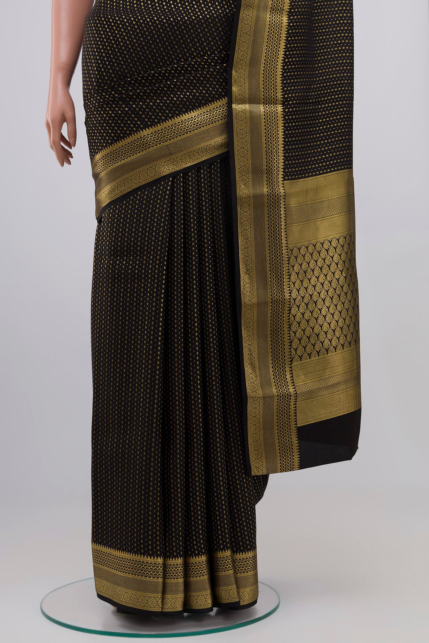 Pleats and pallu of Black Crepe Saree with Zari Butta on the body and Zari Border. 