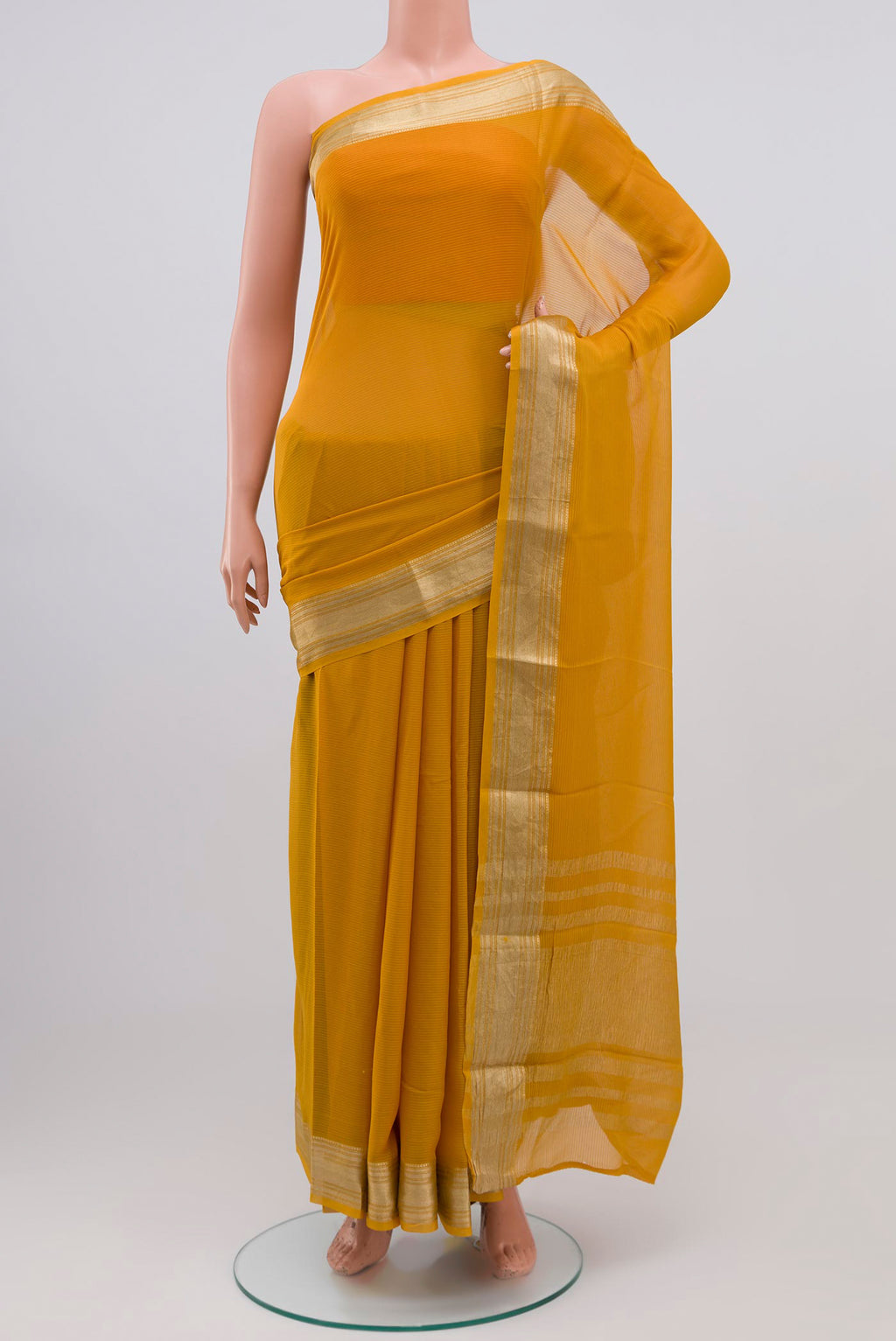 Mustard Georgette Saree with Zari Butta on the body and Zari Border.  displayed on a mannequin