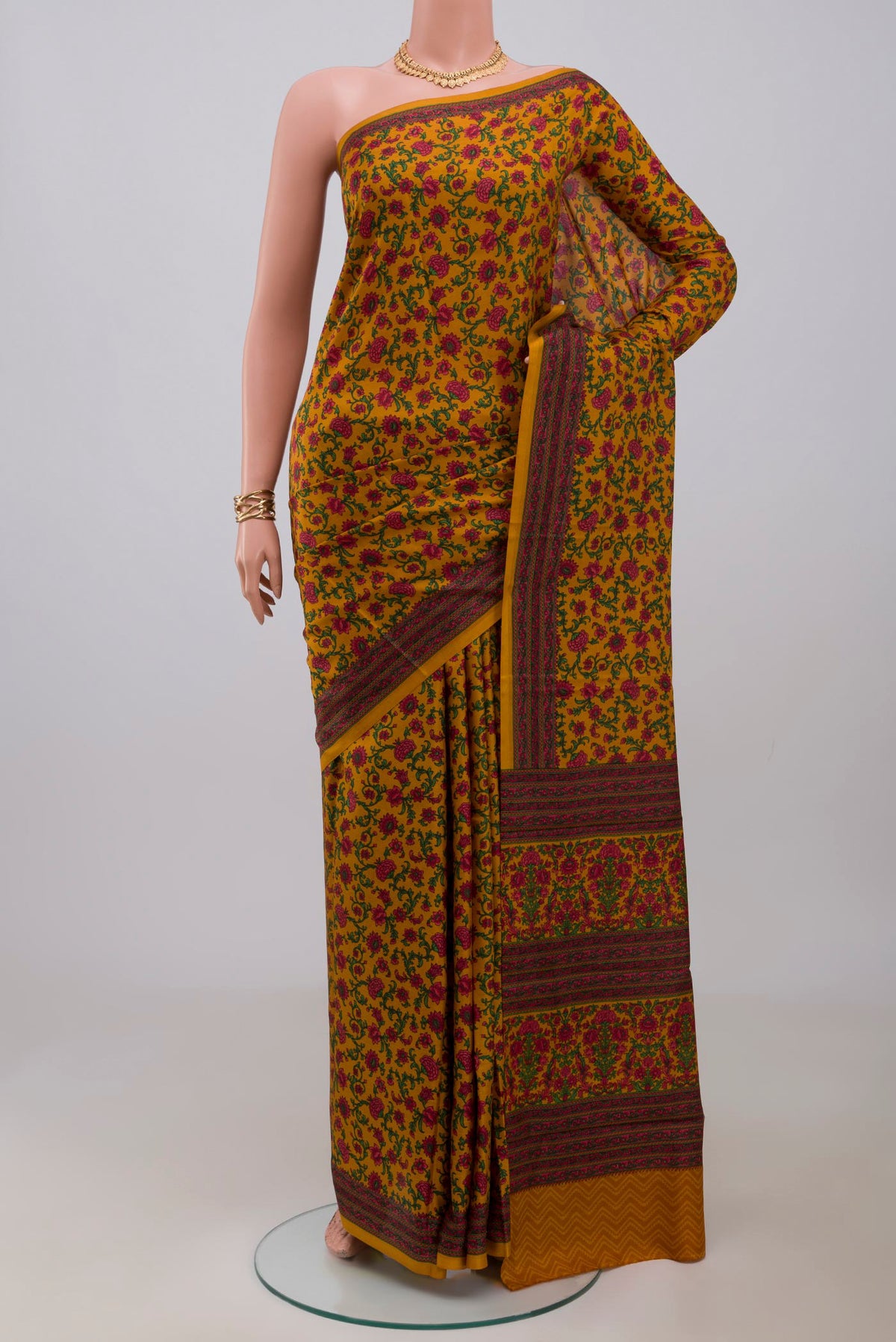 Mustard Printed Silk Saree with Printed design on the body and Printed Border.  displayed on a mannequin