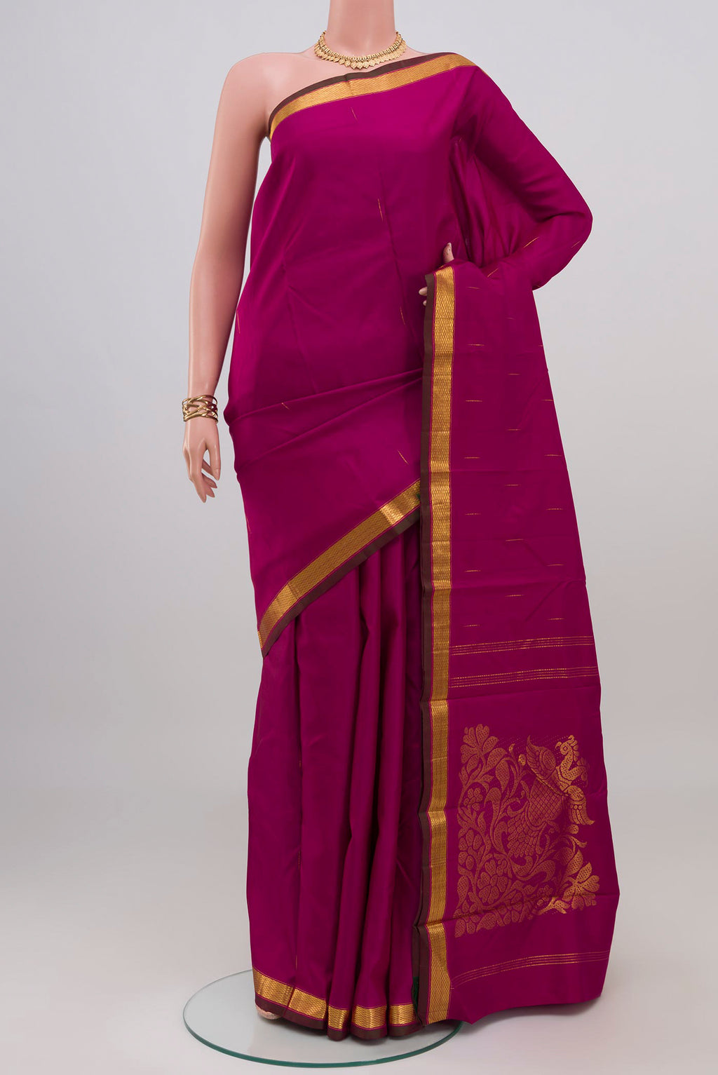 Magenta Kanjivaram Silk Saree with Zari Butta on the body and Zari Border.  displayed on a mannequin