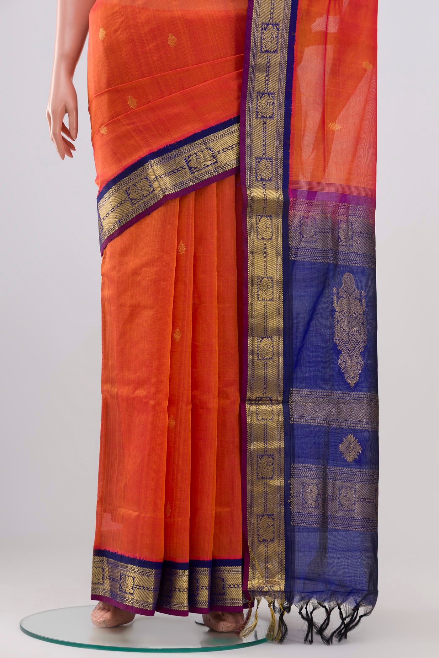 Pleats and pallu of Orange Silk Cotton Saree with Zari Butta on the body and Zari Border. 