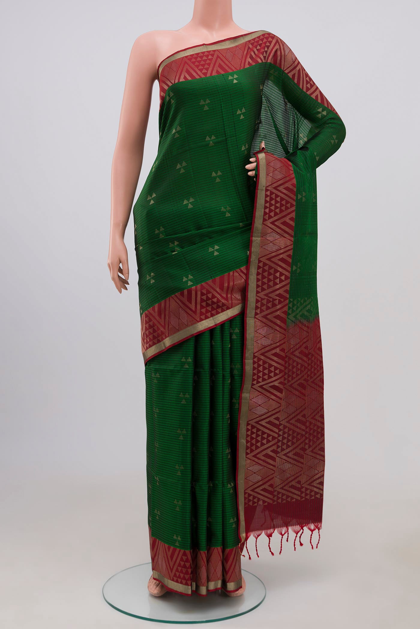 Green Soft Silk Saree with Zari Butta on the body and Fancy Border.  displayed on a mannequin