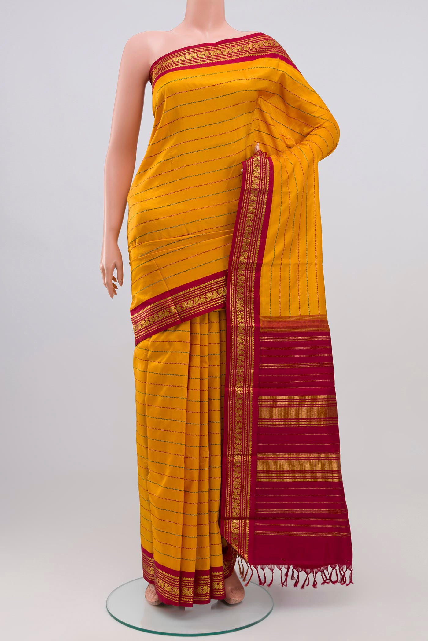 Pure Silk Pure Zari Mustard Kanjivaram Saree with Veldhari on the body and Zari Border.  displayed on a mannequin