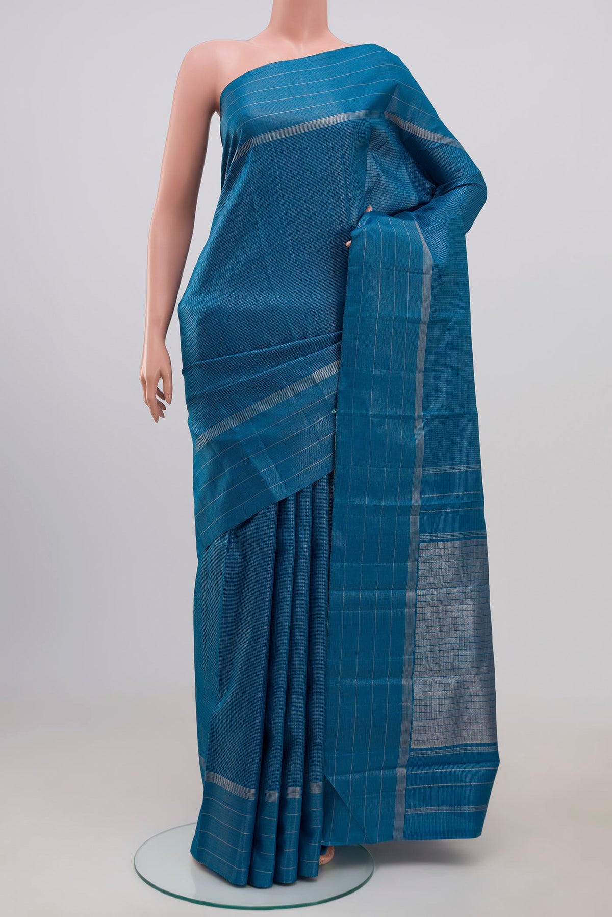Pure Silk Pure Zari Blue Kanchipuram Saree with Checked design on the body and Thin Zari Line.  displayed on a mannequin