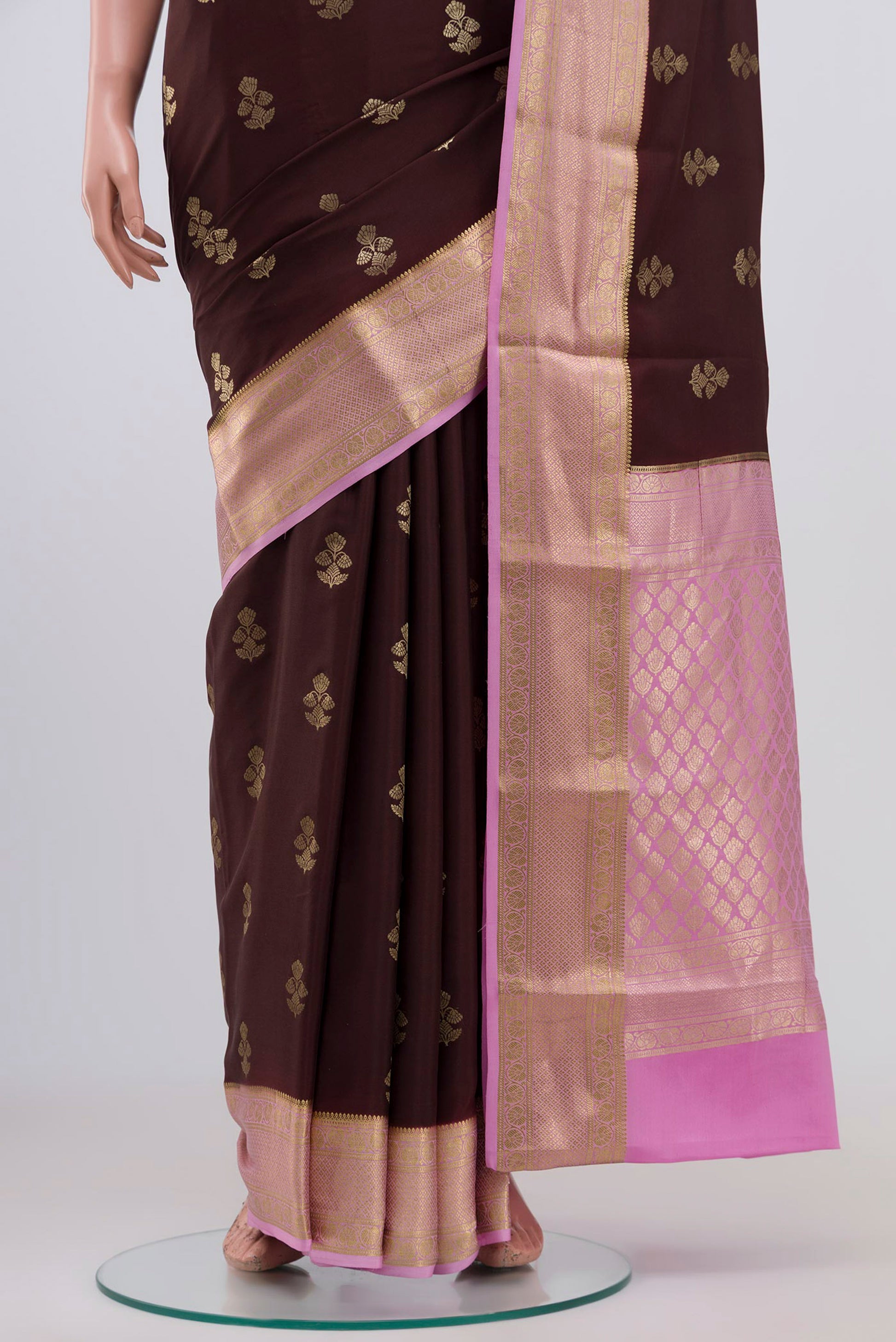 Pleats and pallu of Brown Crepe Saree with Zari Butta on the body and Zari Border. 