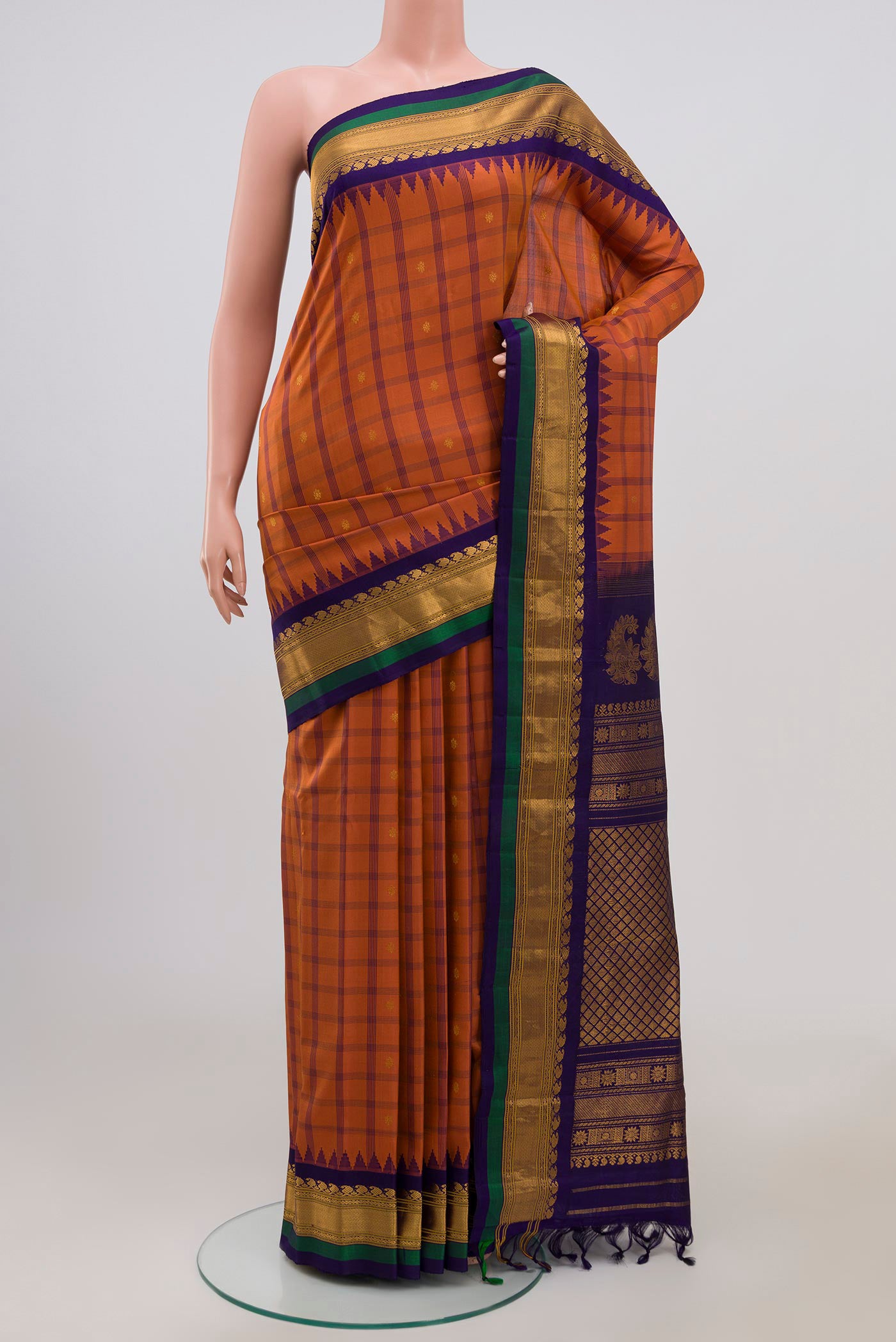 Rust Gadwal Silk Saree with Zari Butta on the body and Zari Border.  displayed on a mannequin