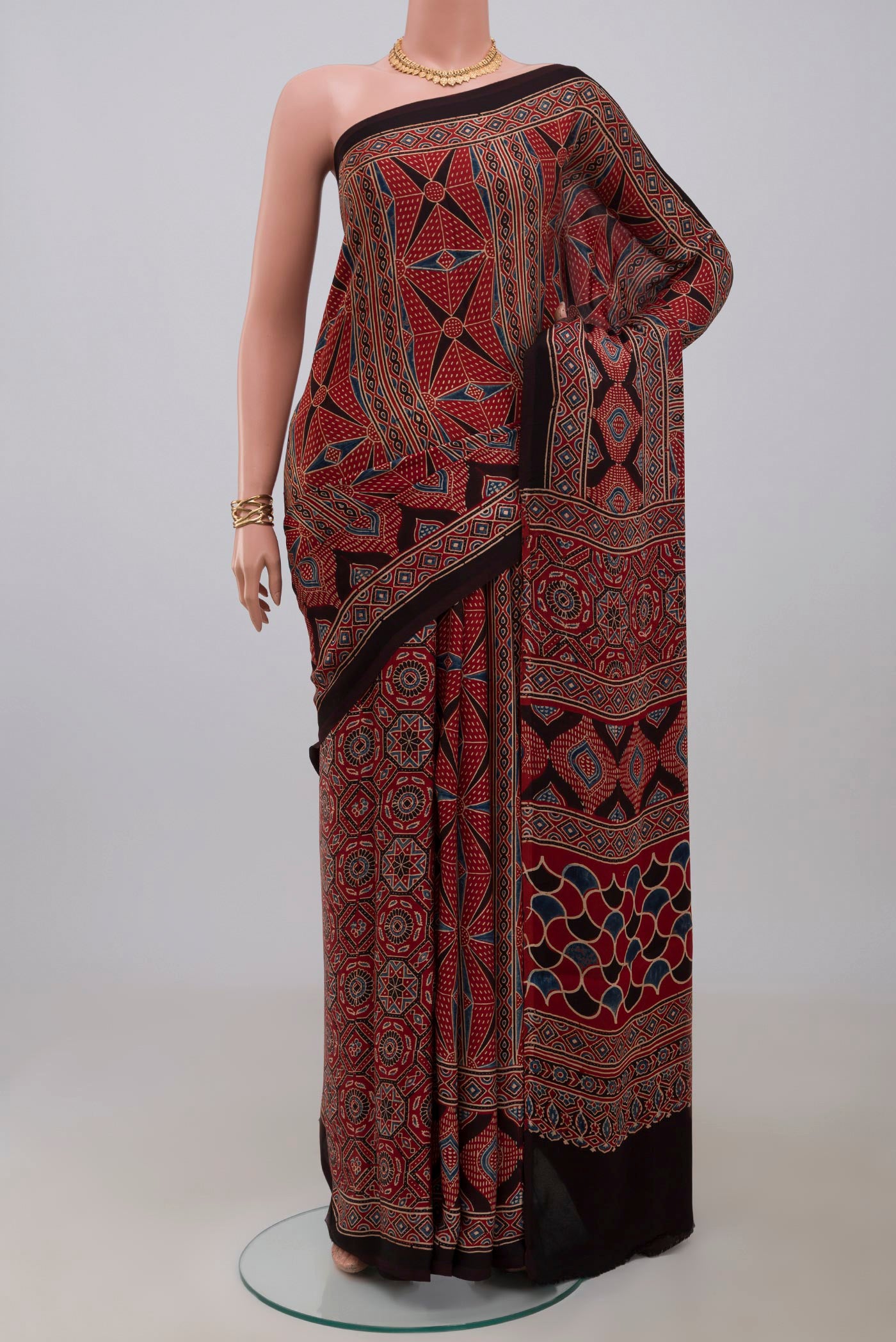 Maroon Blended Satin Silk Saree with Ajrakh Print on the body and Printed Border.  displayed on a mannequin