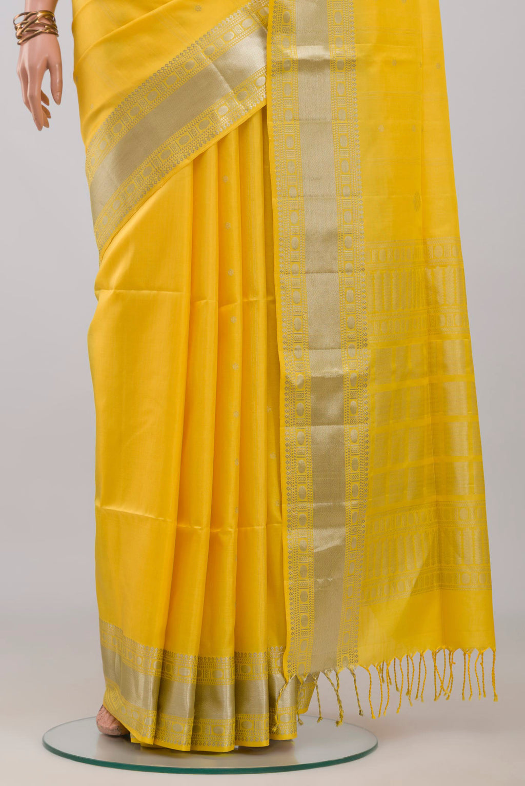 Pleats and pallu of Yellow Soft Silk Saree with Zari Butta on the body and Zari Border. 