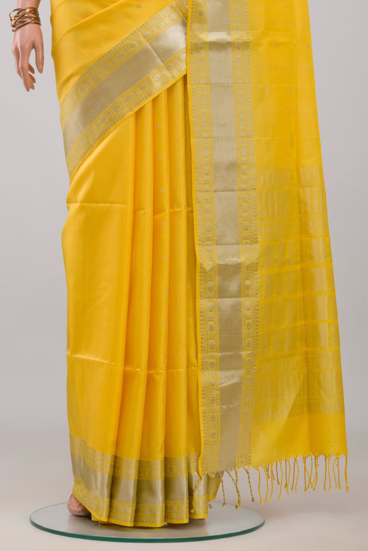 Pleats and pallu of Yellow Soft Silk Saree with Zari Butta on the body and Zari Border. 