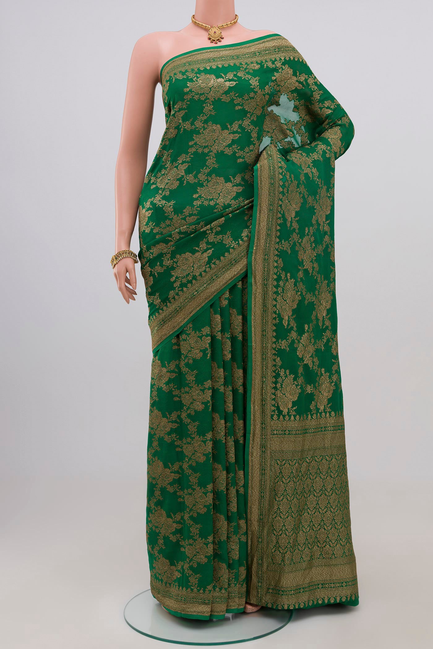 Green Georgette Saree with Fancy on the body and Zari Border.  displayed on a mannequin