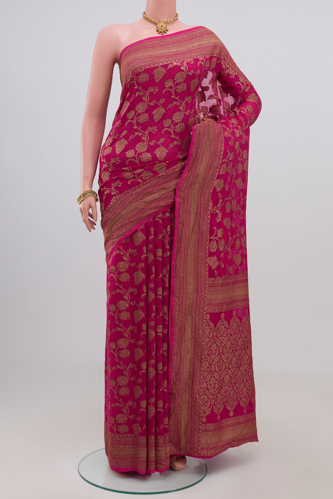 Pink Georgette Saree with Fancy on the body and Zari Border.  displayed on a mannequin