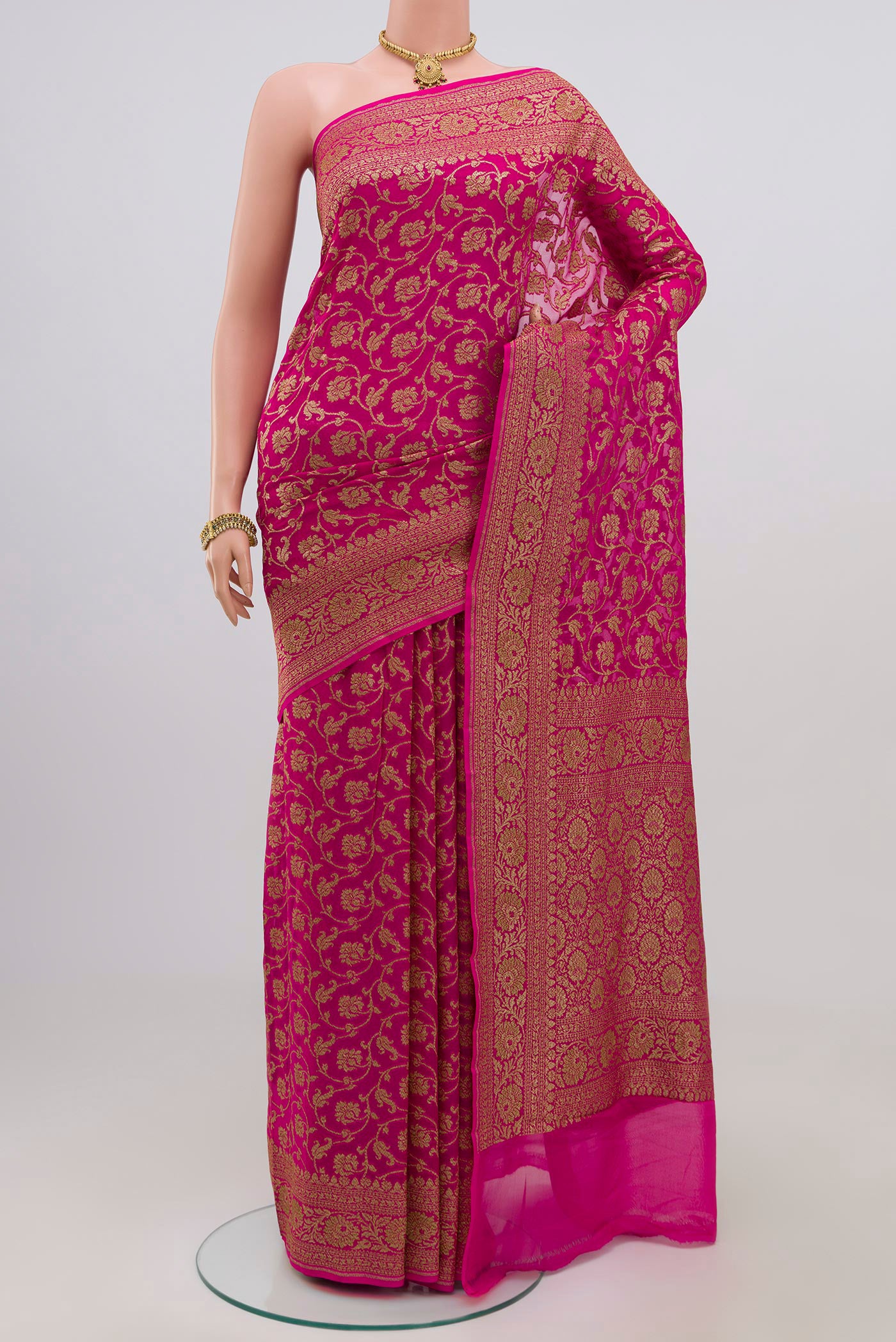 Pink Georgette Saree with Fancy on the body and Zari Border.  displayed on a mannequin