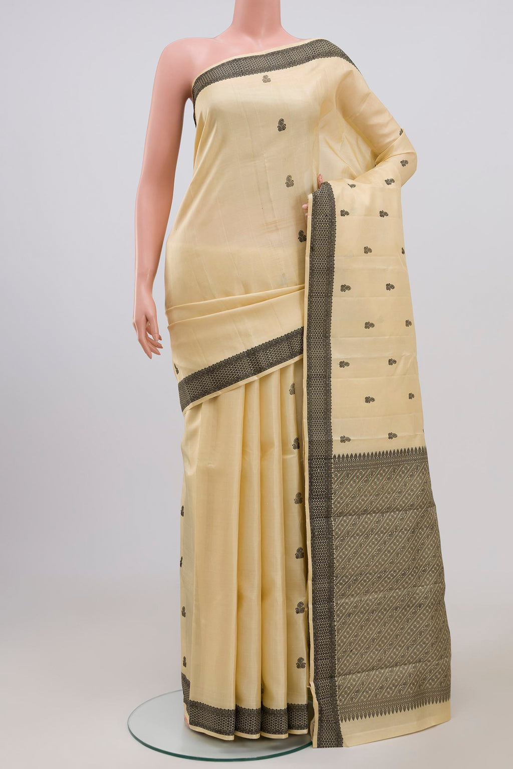 Cream Kanchipuram Saree with Thread Butta on the body and Thread Border.  displayed on a mannequin