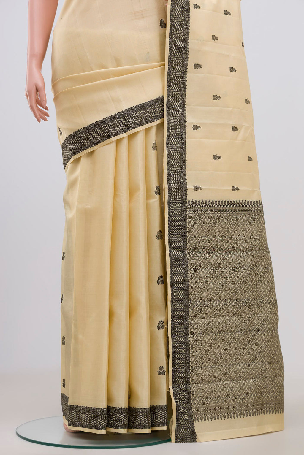 Pleats and pallu of Cream Kanchipuram Saree with Thread Butta on the body and Thread Border. 