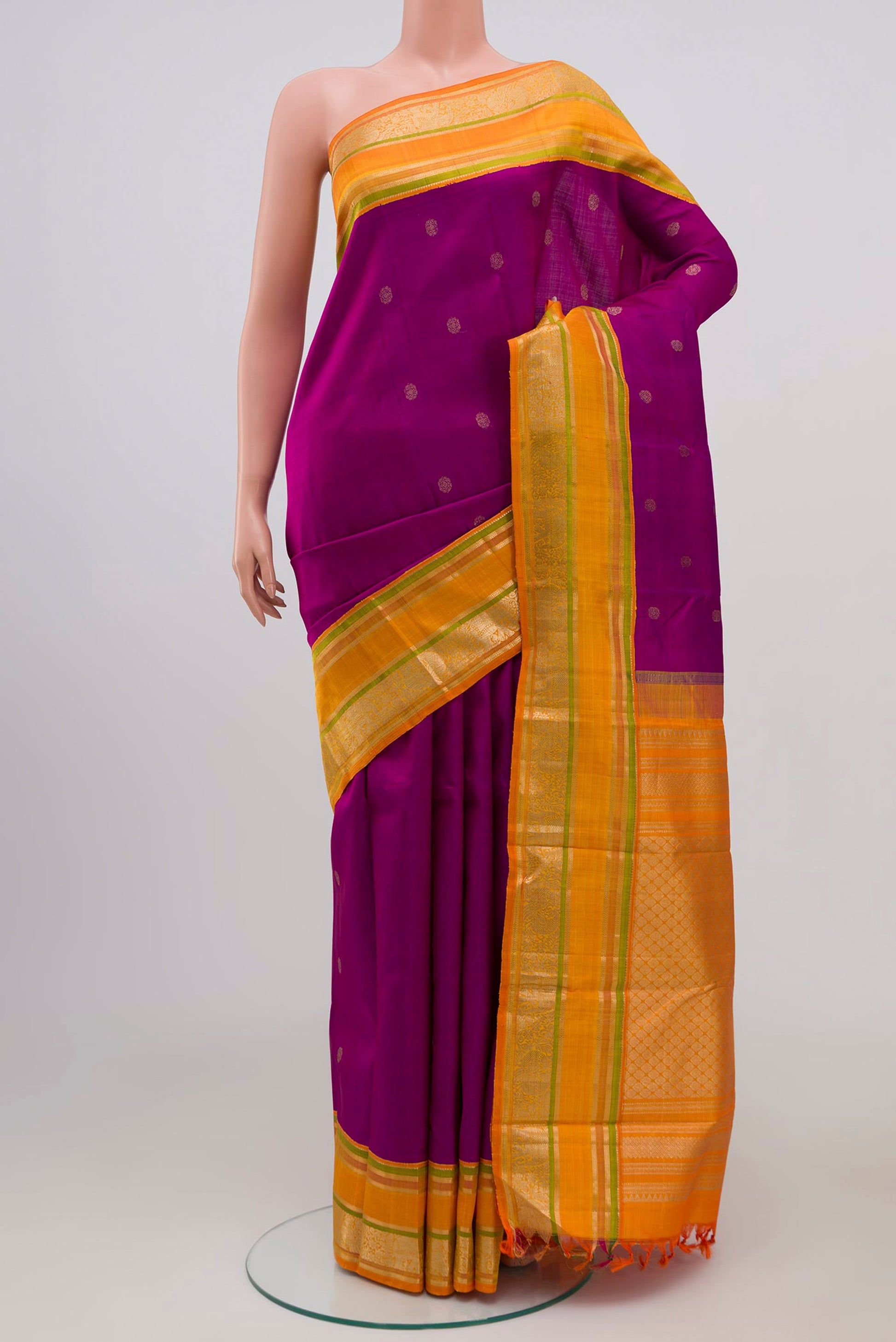 Magenta Kanjivaram Silk Saree with Zari Butta on the body and Zari Border.  displayed on a mannequin