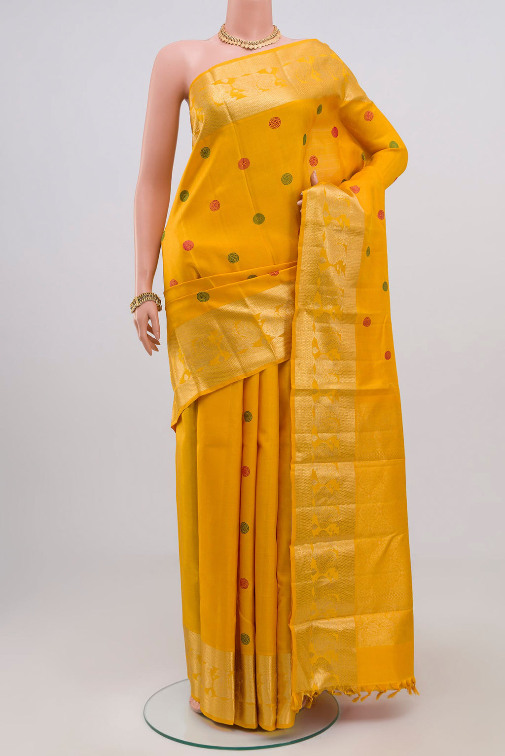 Yellow Kanjivaram Silk Saree with Thread Butta on the body and Zari Border.  displayed on a mannequin