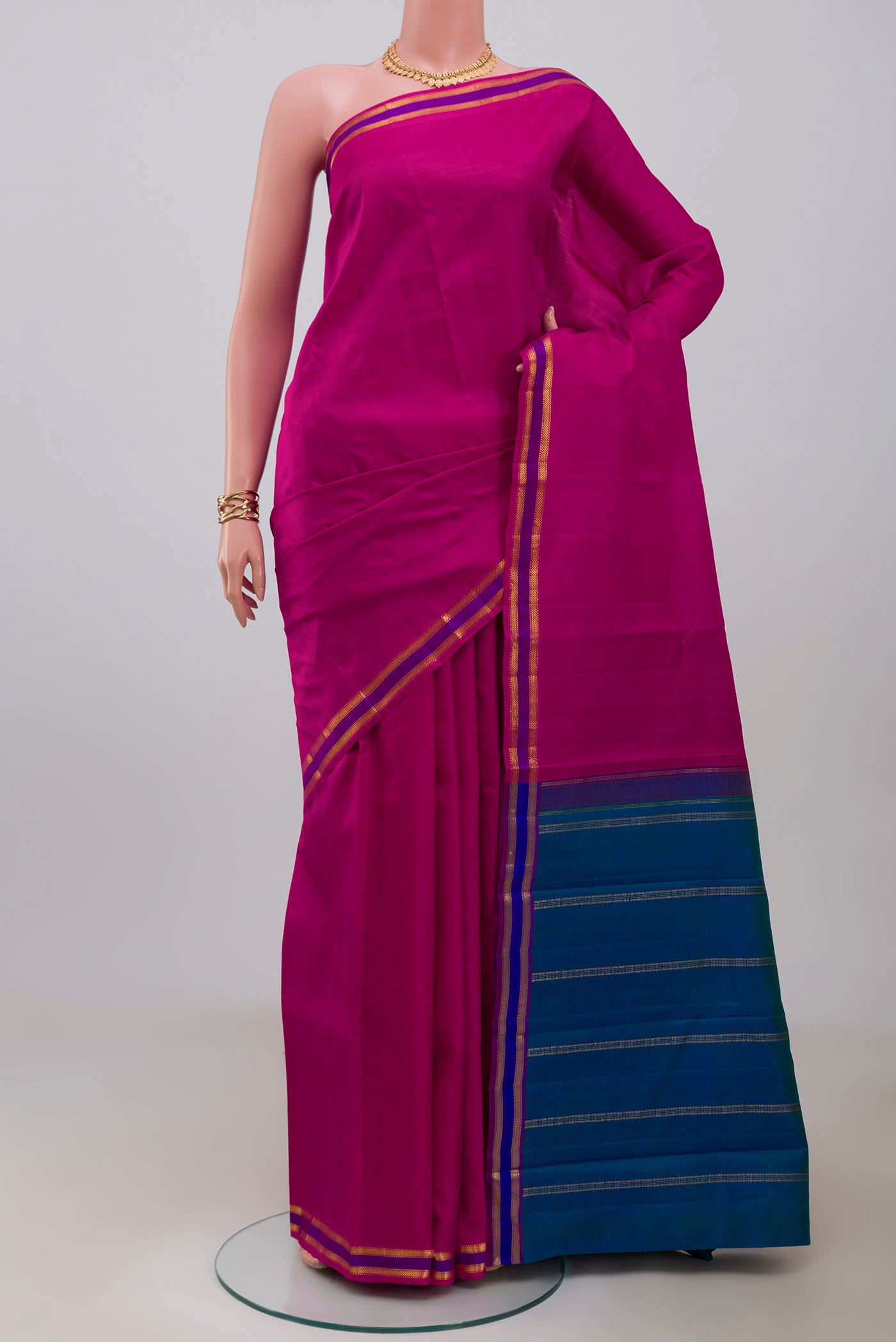 Rani Pink Kanjivaram Saree with Plain Body and Zari And Thread Border.  displayed on a mannequin