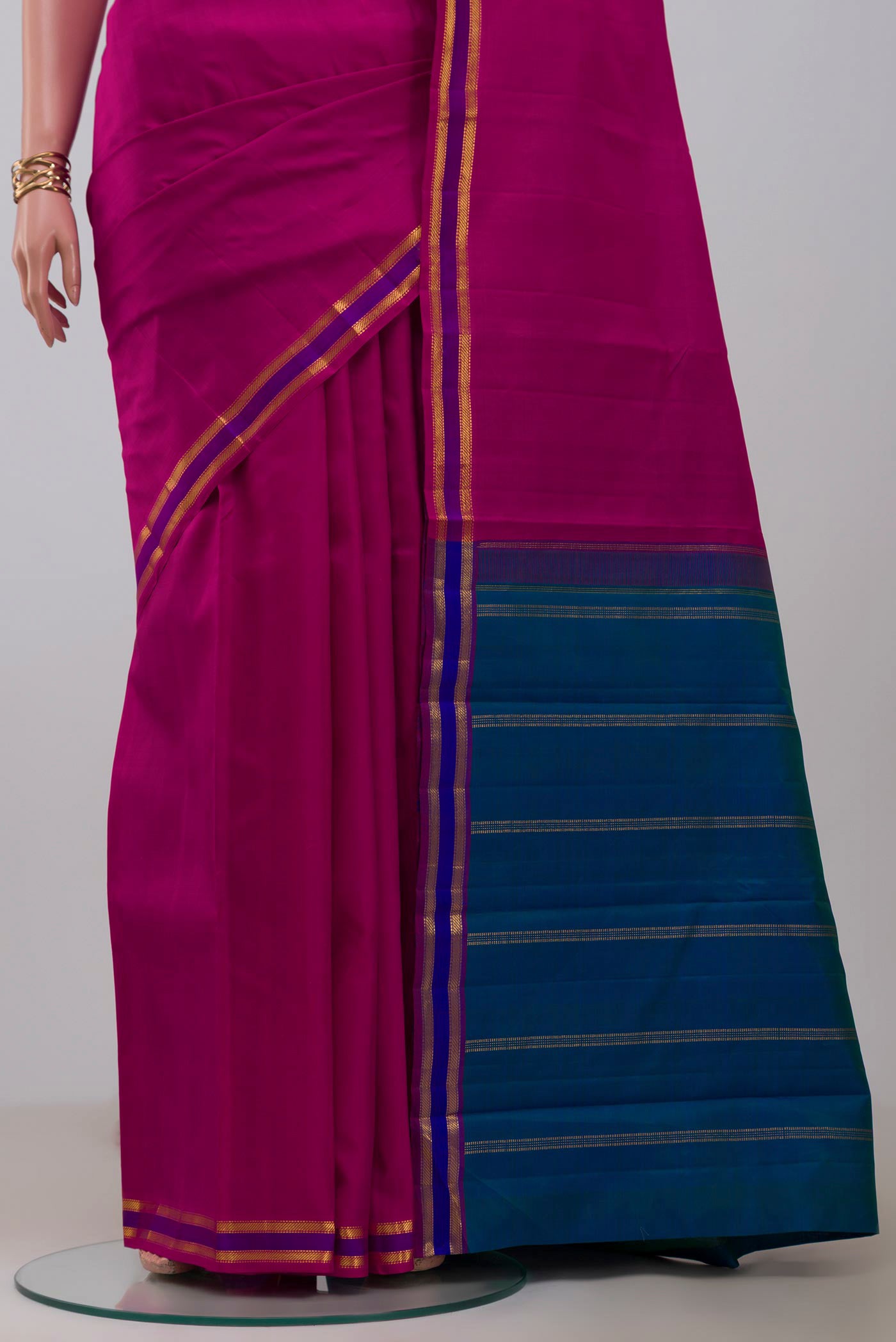 Pleats and pallu of Rani Pink Kanjivaram Saree with Plain Body and Zari And Thread Border. 