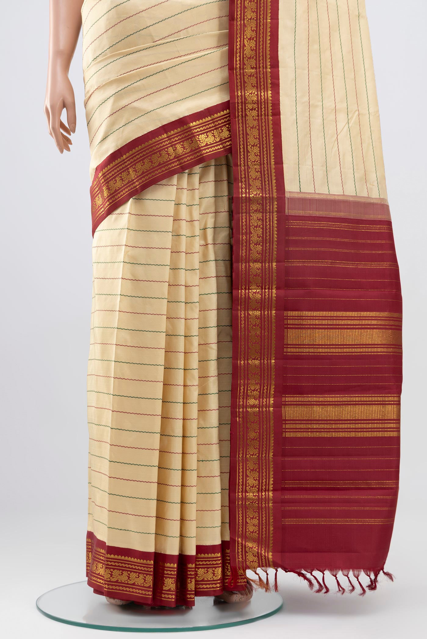 Pleats and pallu of Pure Silk Pure Zari Cream Kanjivaram Saree with Veldhari on the body and Zari Border. 
