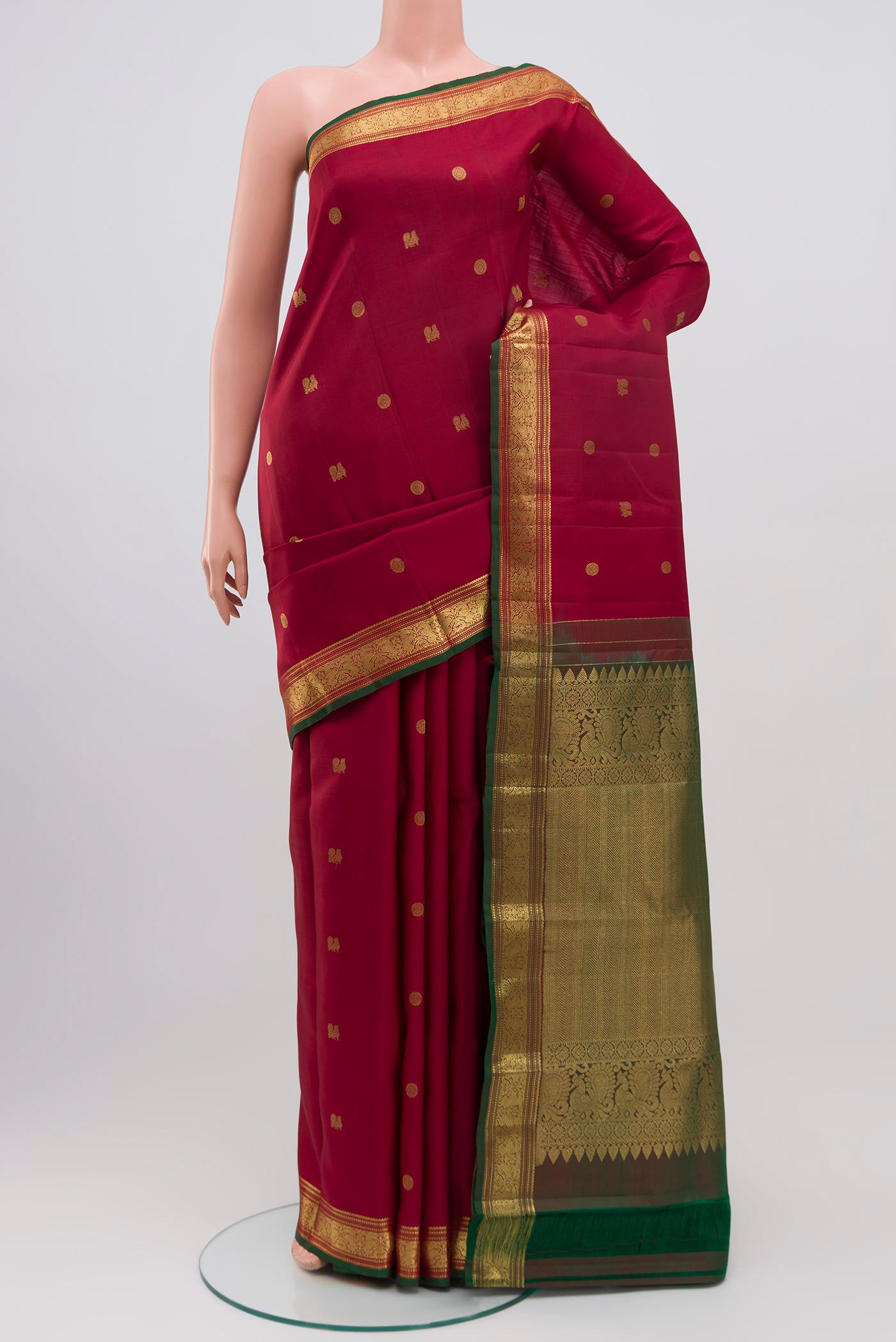 Maroon Kanchipuram Saree with Zari Butta on the body and Zari Border.  displayed on a mannequin