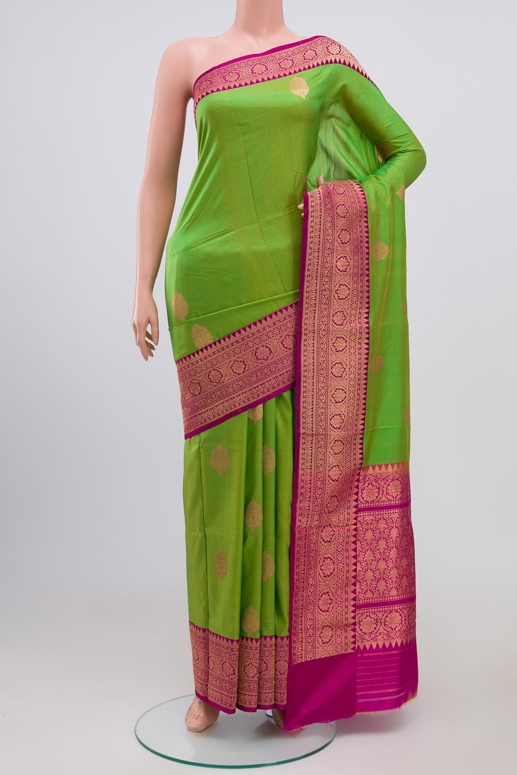 Parrot Green Banarasi Katan Silk Saree with Zari Butta on the body and Zari Border.  displayed on a mannequin