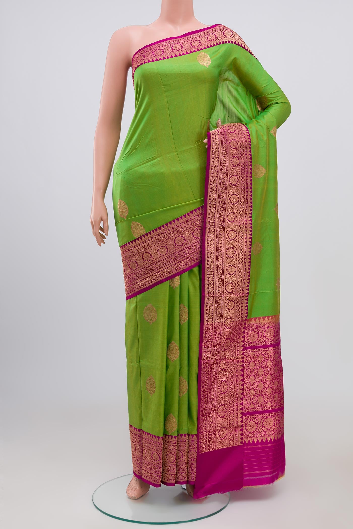 Parrot Green Banarasi Katan Silk Saree with Zari Butta on the body and Zari Border.  displayed on a mannequin