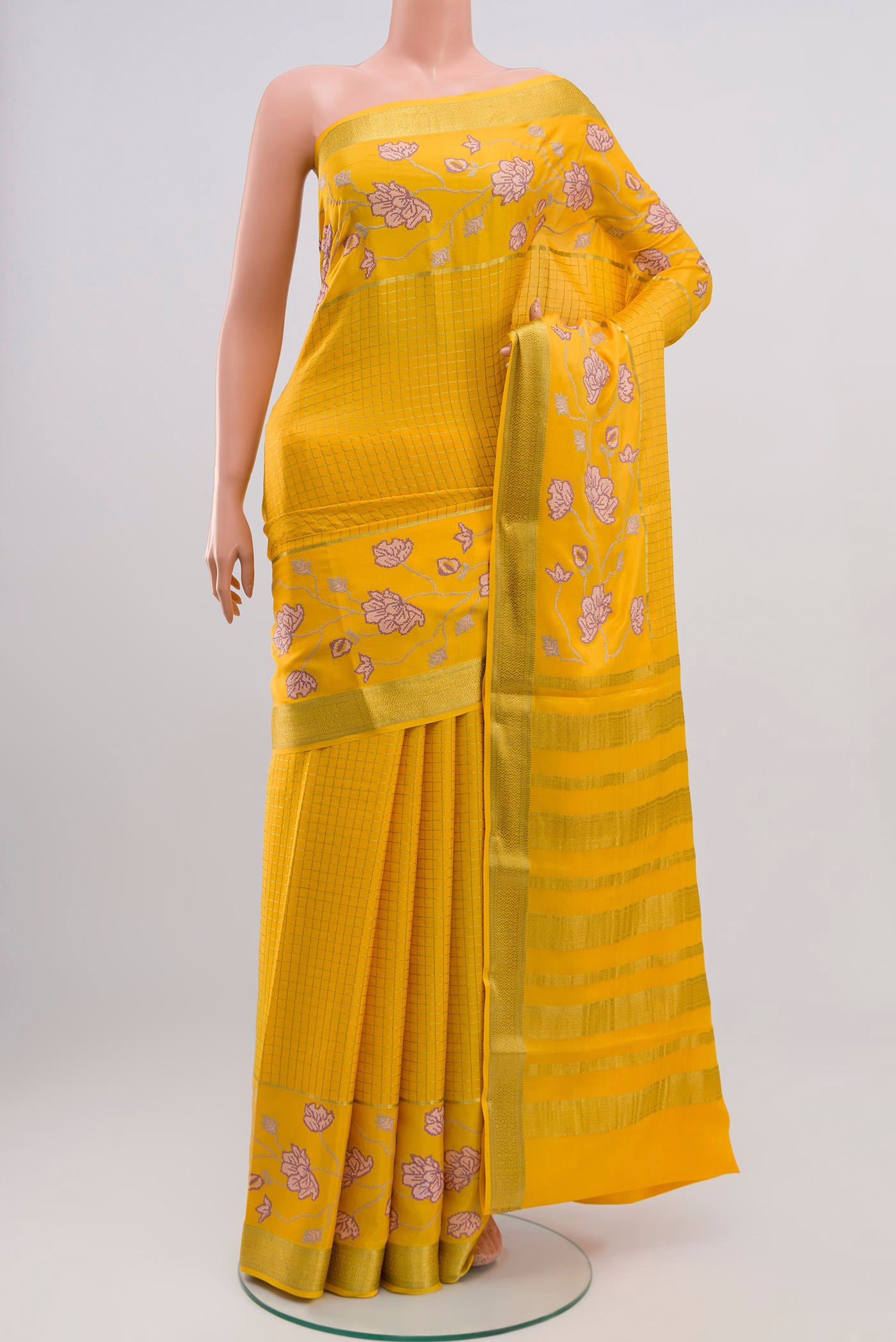 Yellow Crepe Saree with Checked design on the body and Zari Border.  displayed on a mannequin