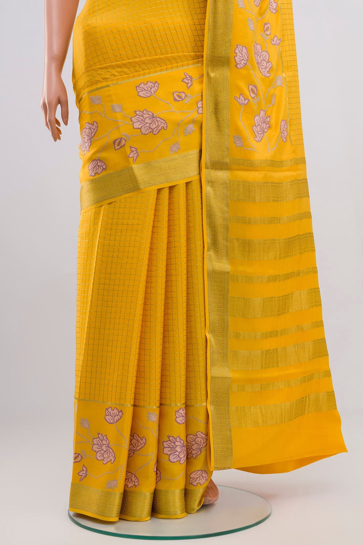 Pleats and pallu of Yellow Crepe Saree with Checked design on the body and Zari Border. 
