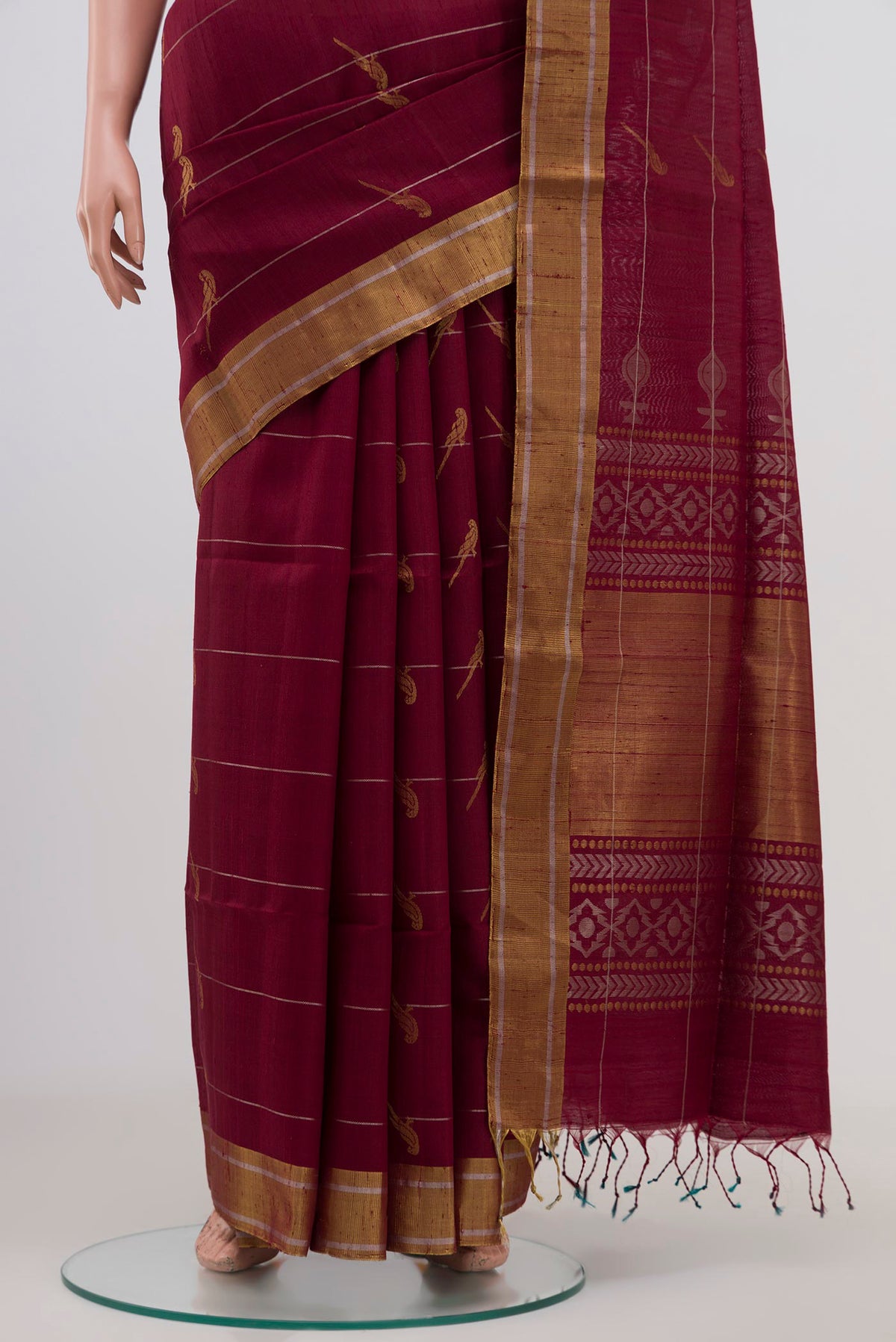 Pleats and pallu of Maroon Soft Silk Saree with Zari Butta on the body and Zari Border. 