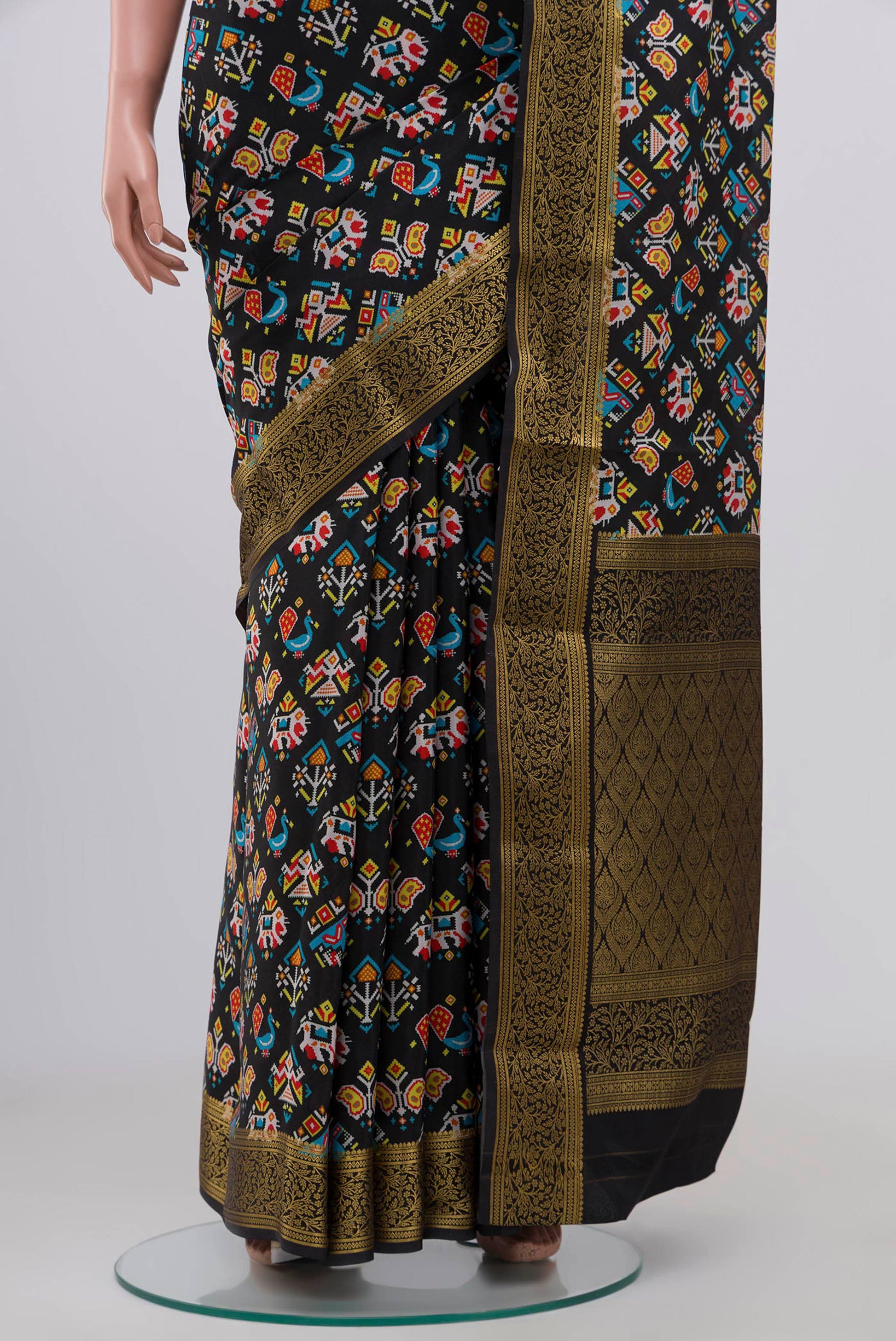 Pleats and pallu of Black Crepe Saree with Floral Print on the body and Zari Border. 