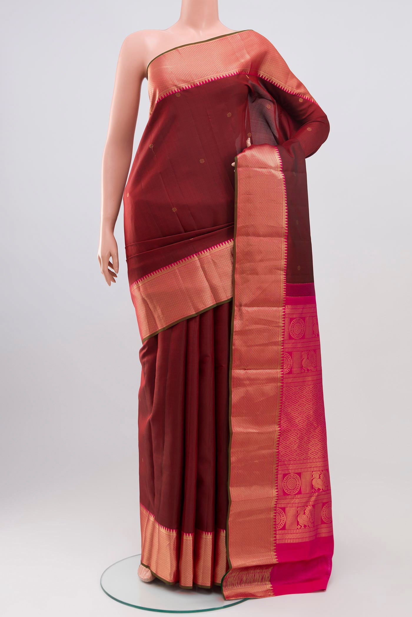 Maroon Kanchipuram Saree with Zari Butta on the body and Zari Border.  displayed on a mannequin