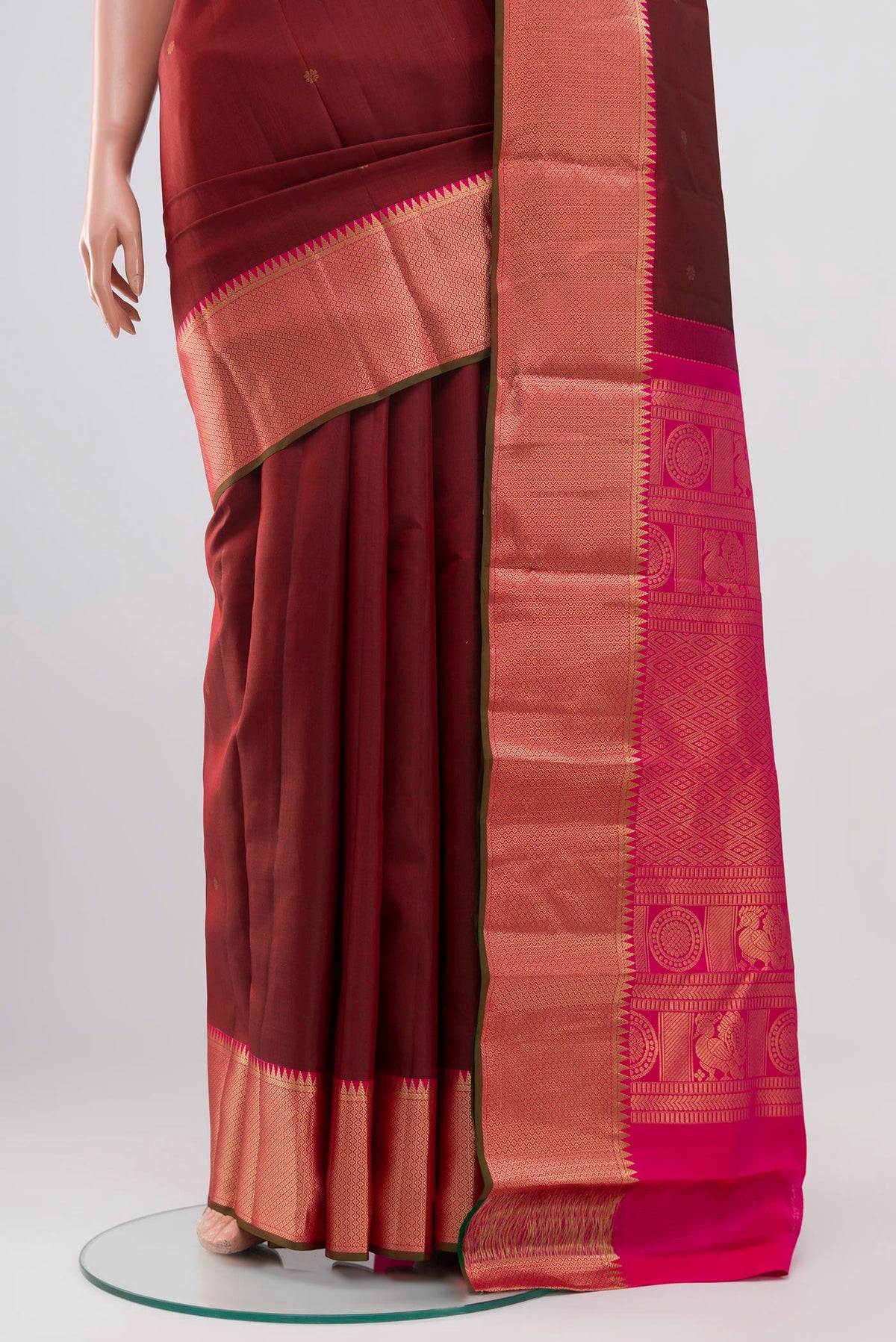 Pleats and pallu of Maroon Kanchipuram Saree with Zari Butta on the body and Zari Border. 