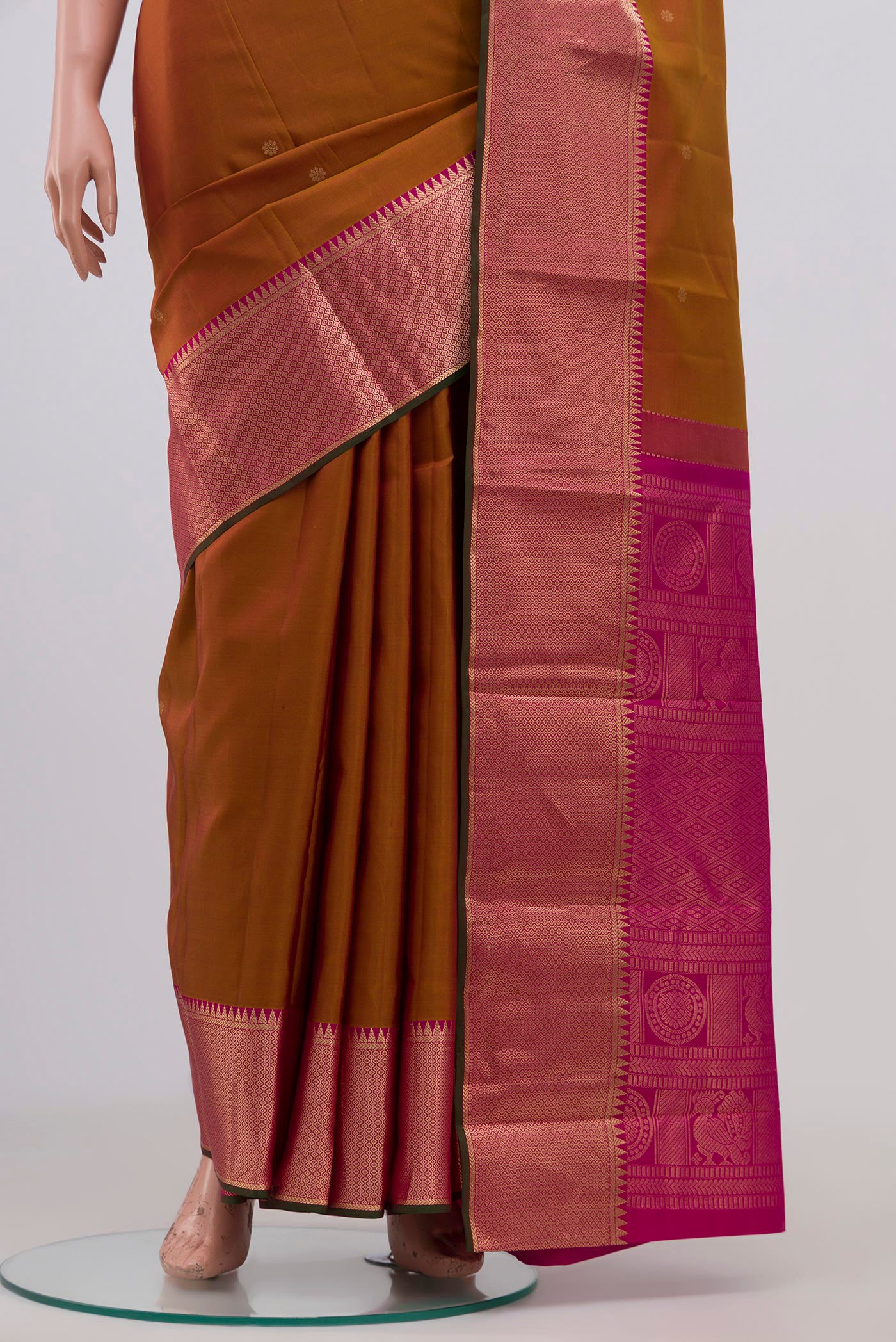 Pleats and pallu of Mustard Kanchipuram Saree with Zari Butta on the body and Zari Border. 