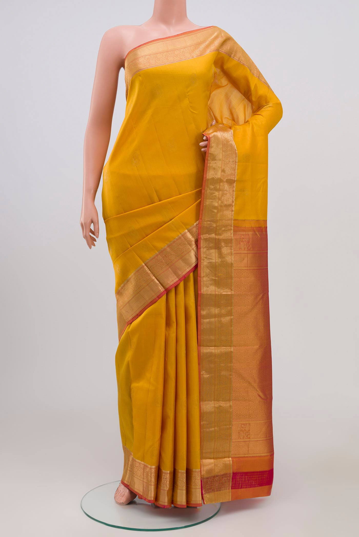 Yellow Kanchipuram Silk Saree with Zari Butta on the body and Zari Border.  displayed on a mannequin