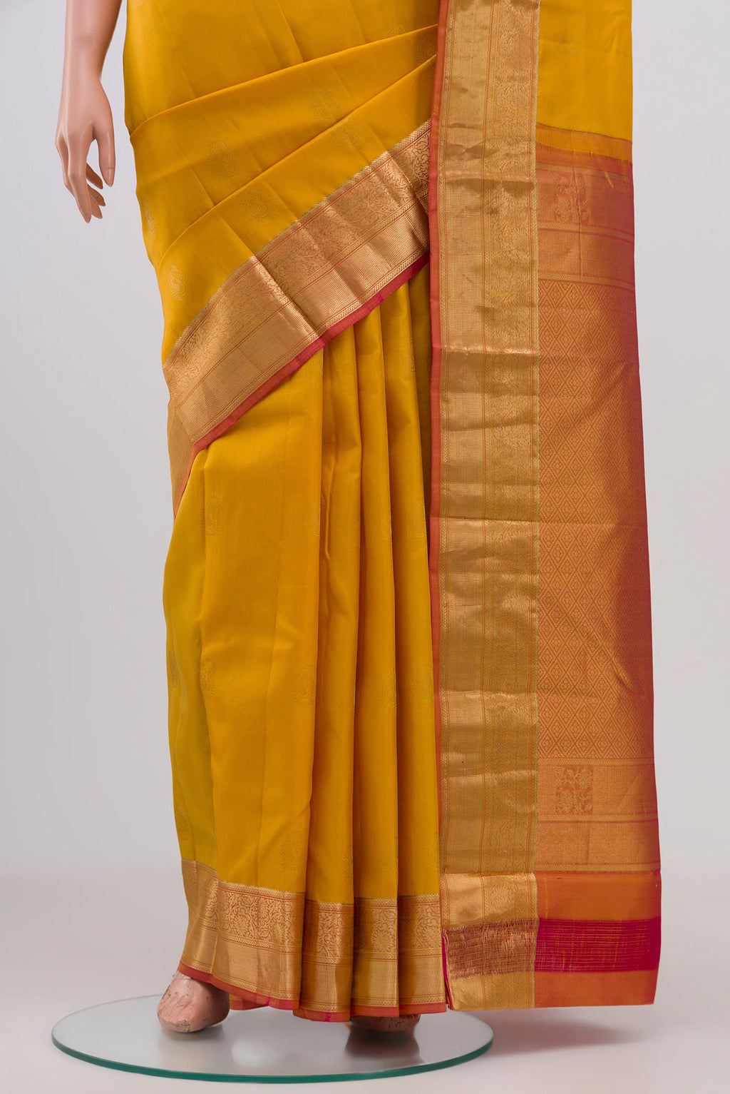 Pleats and pallu of Yellow Kanchipuram Silk Saree with Zari Butta on the body and Zari Border. 