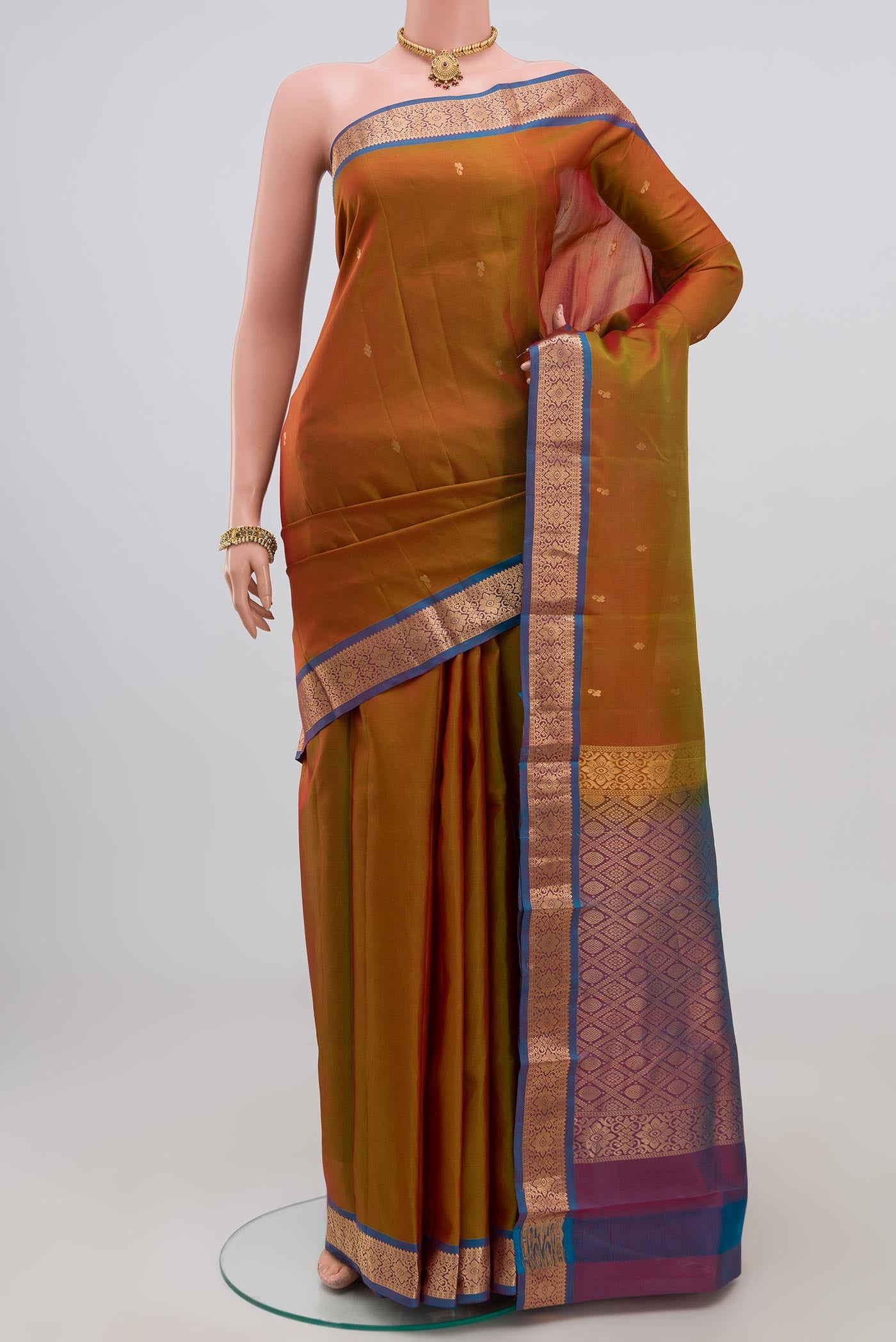 Green Kanjivaram Saree with Zari Butta on the body and Zari Border.  displayed on a mannequin