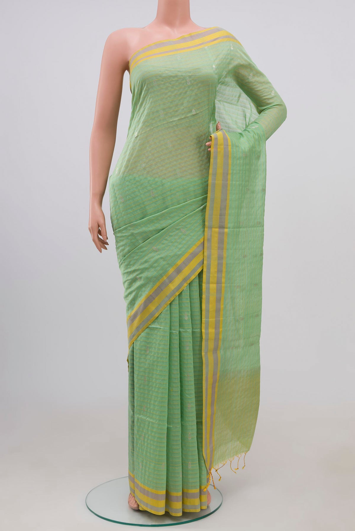 Light Green Coimbatore Silk Cotton Saree with Zari Butta on the body and Thread Border.  displayed on a mannequin