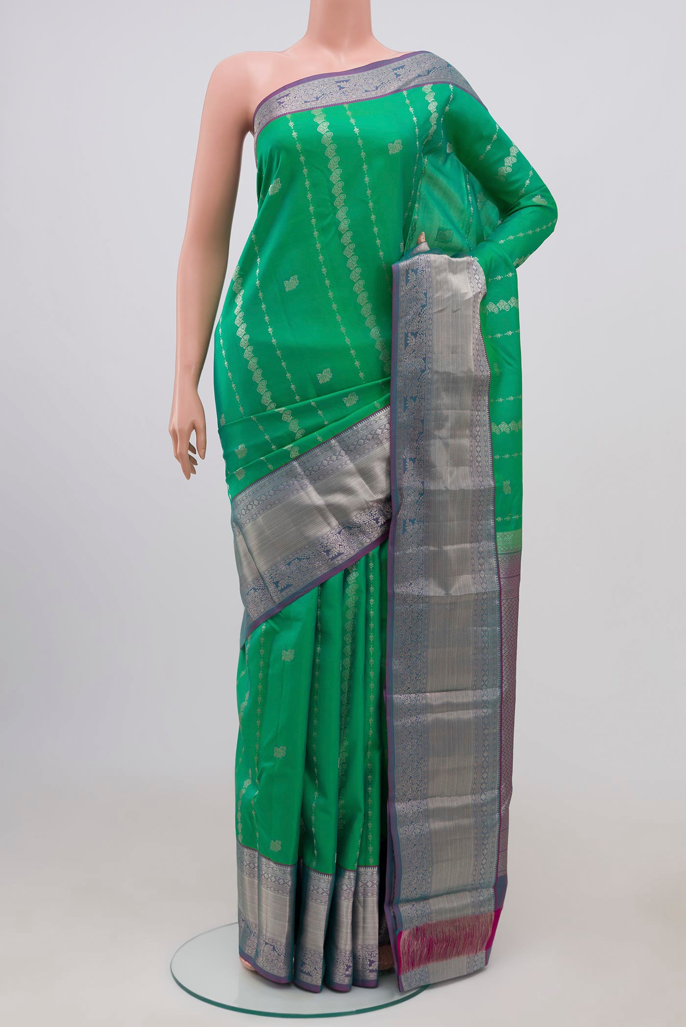Green Kanchipuram Silk Saree with Zari Butta on the body and Zari Border.  displayed on a mannequin
