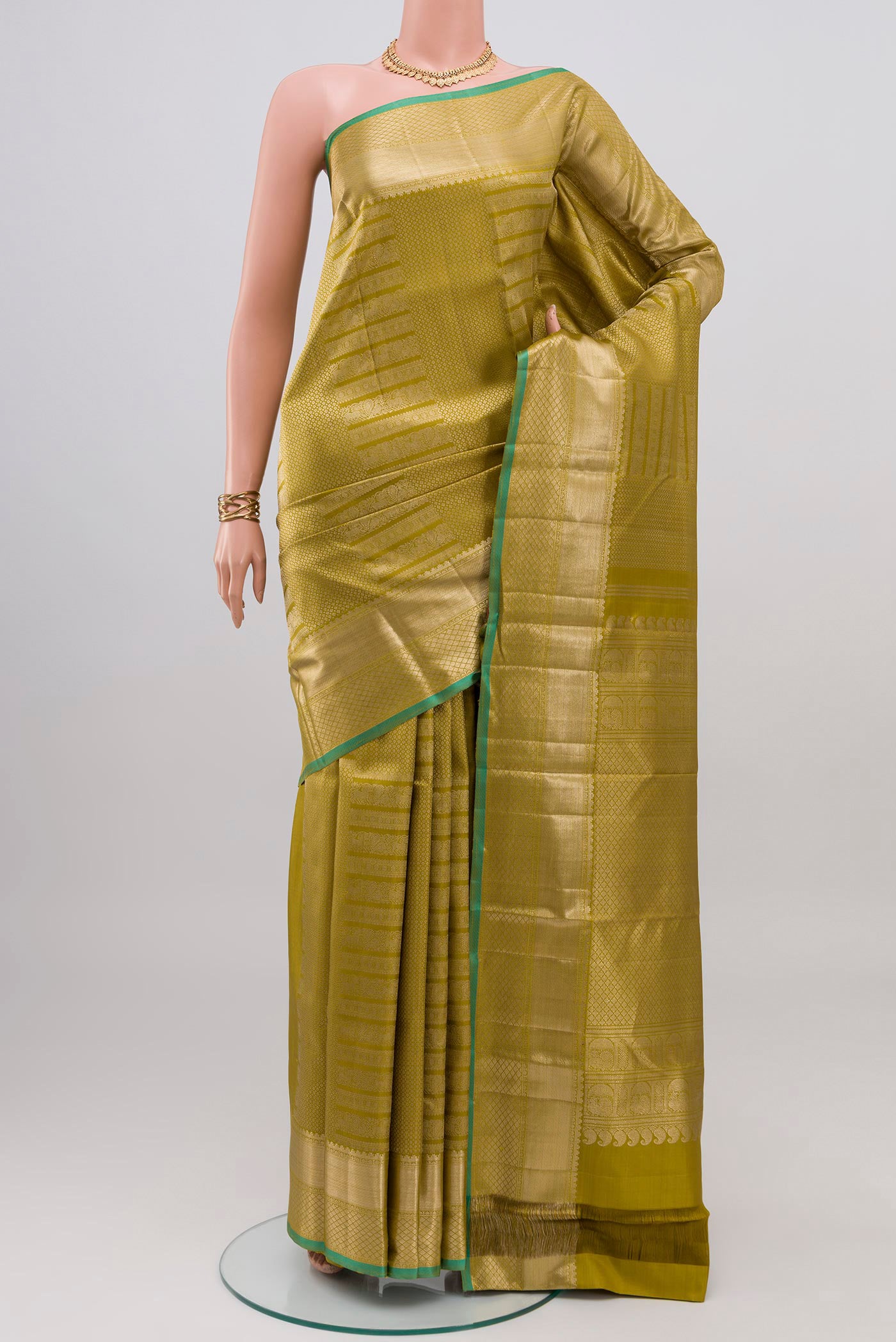 Mehandi Green Kanchipuram Silk Saree with Zari Brocade on the body and Zari Border.  displayed on a mannequin