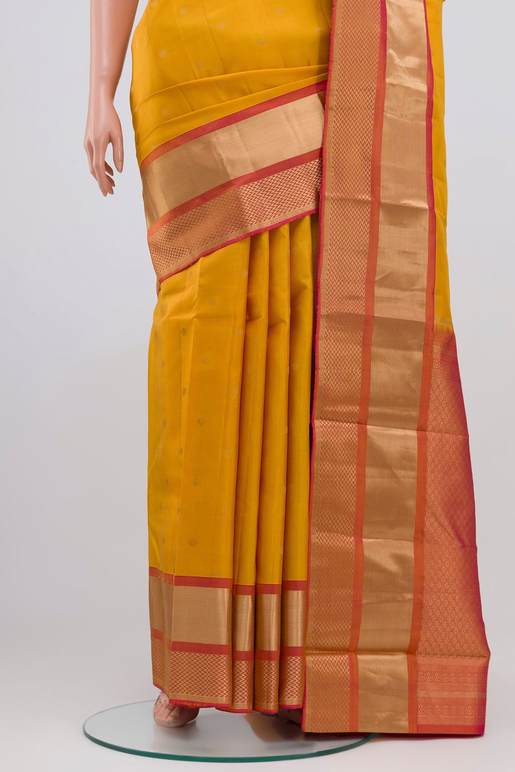 Pleats and pallu of Yellow Kanchipuram Saree with Zari Butta on the body and Zari Border. 