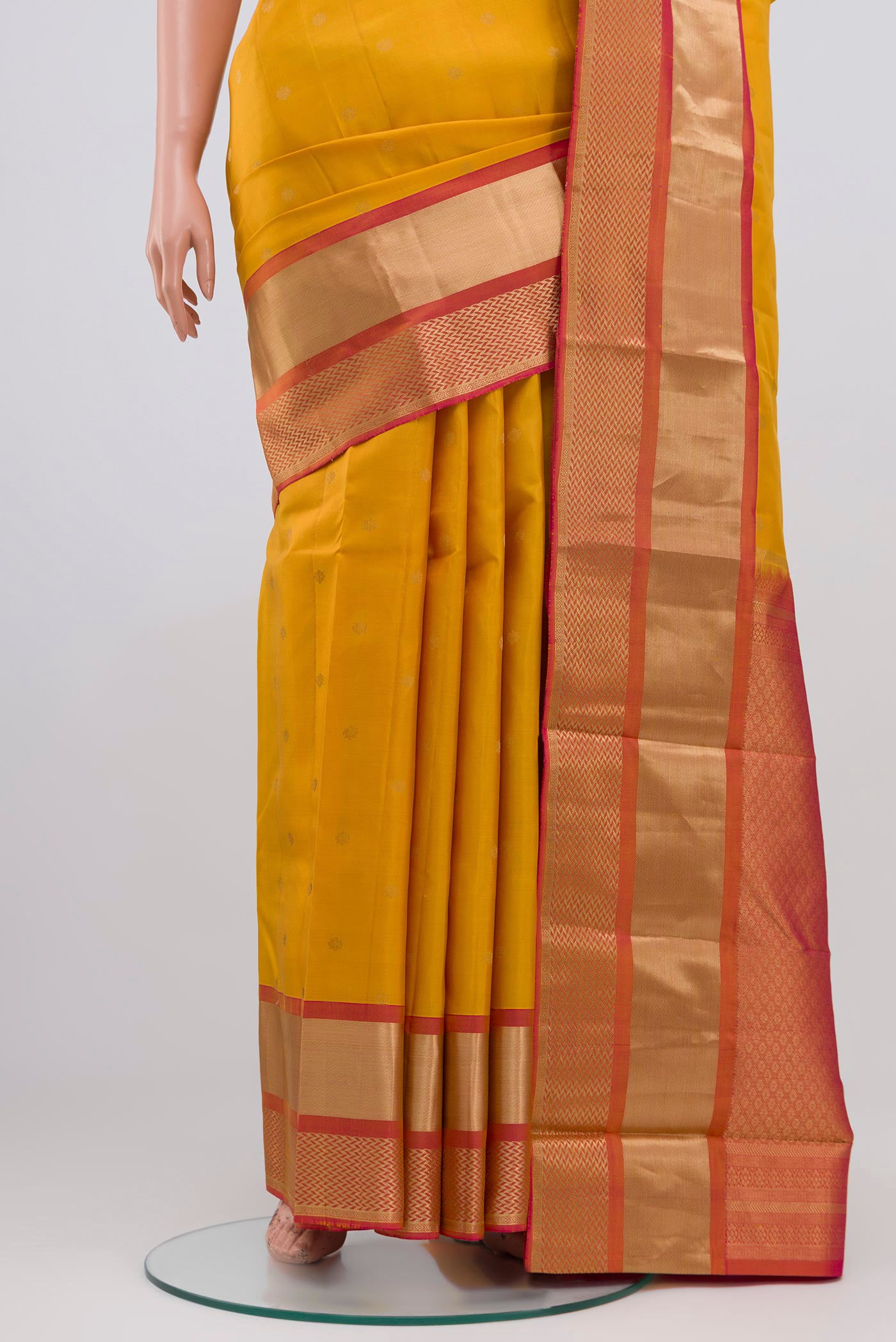 Pleats and pallu of Yellow Kanchipuram Saree with Zari Butta on the body and Zari Border. 