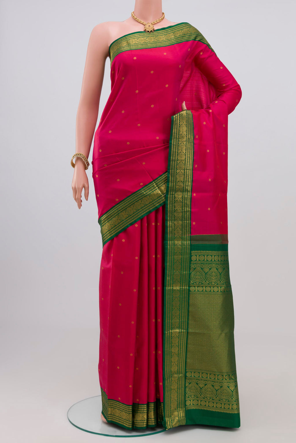 Rani Pink Kanjivaram Silk Saree with Zari Butta on the body and Zari Border.  displayed on a mannequin