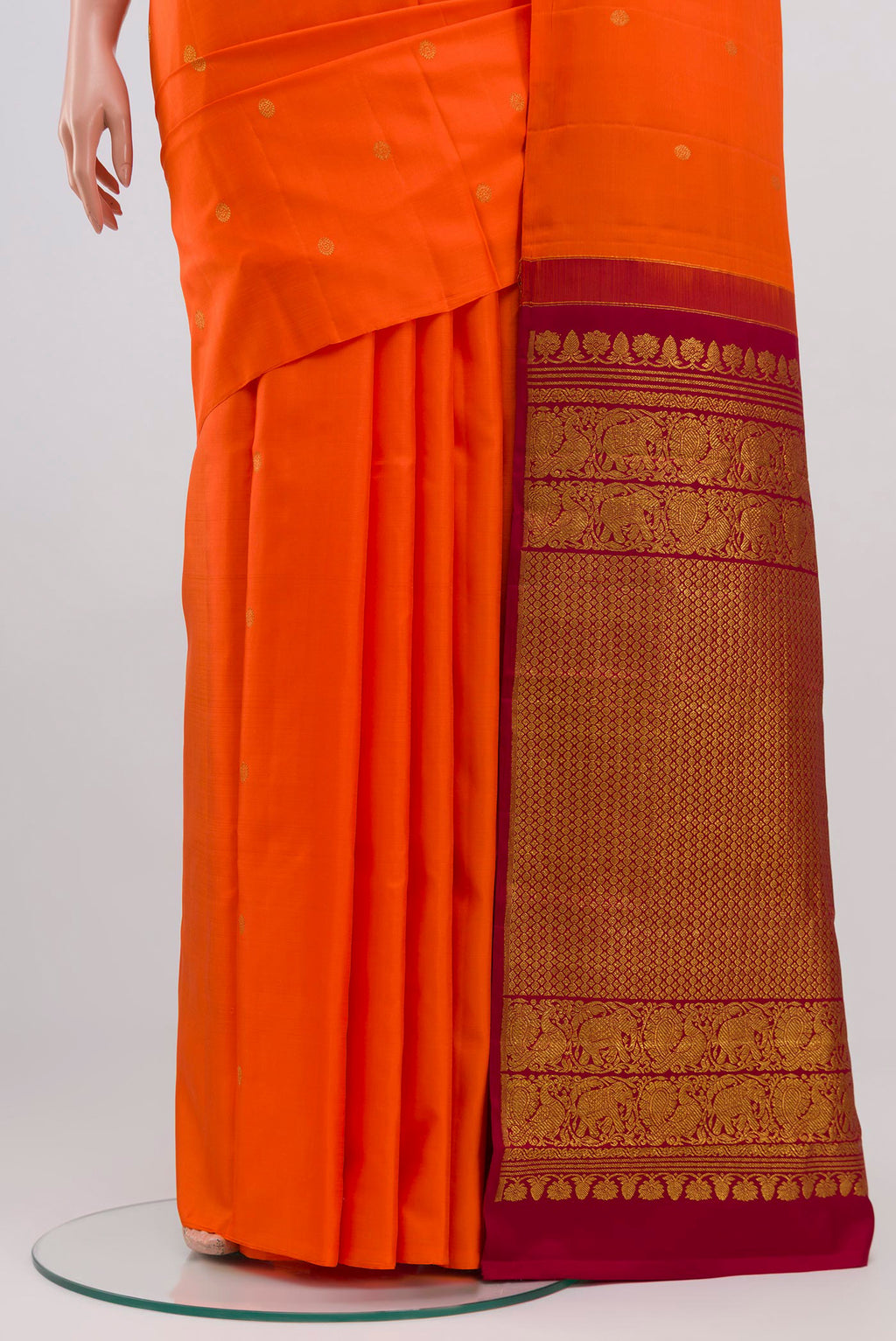 Pleats and pallu of Orange Kanchipuram Saree with Zari Butta on the body and Without Border. 
