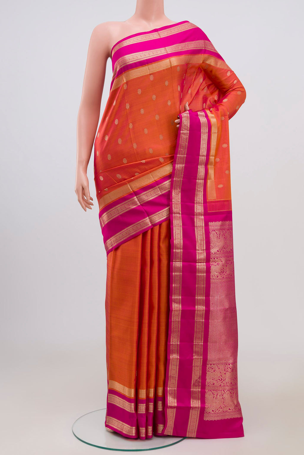 Orange Kanjivaram Saree with Zari Butta on the body and Zari Border.  displayed on a mannequin